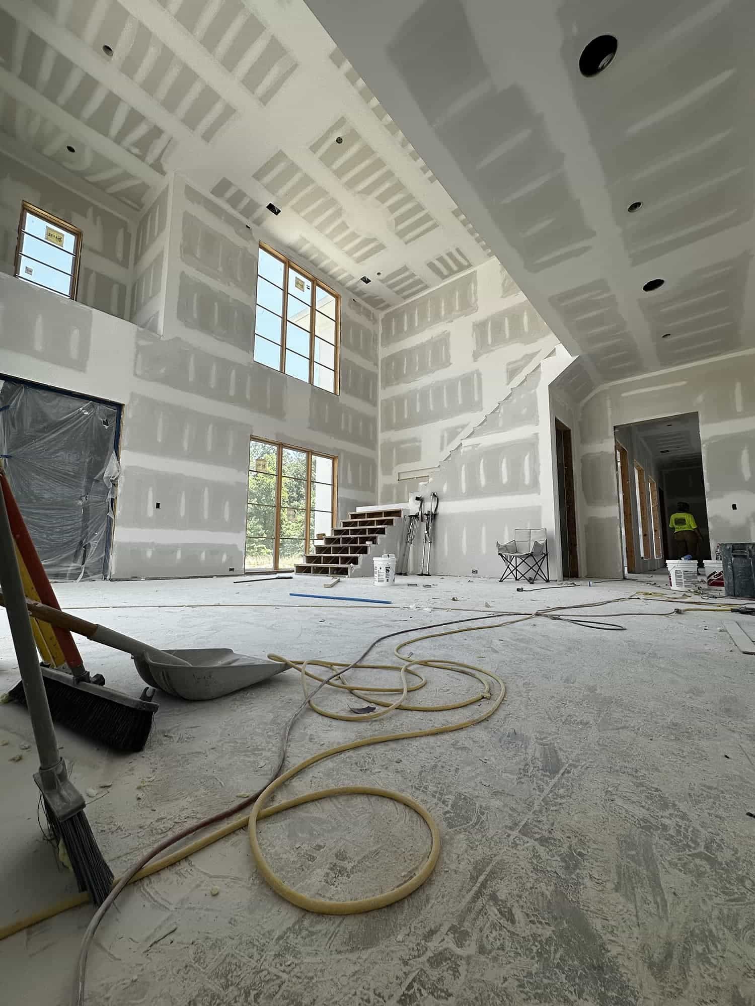 A large room with a staircase and a broom on the floor