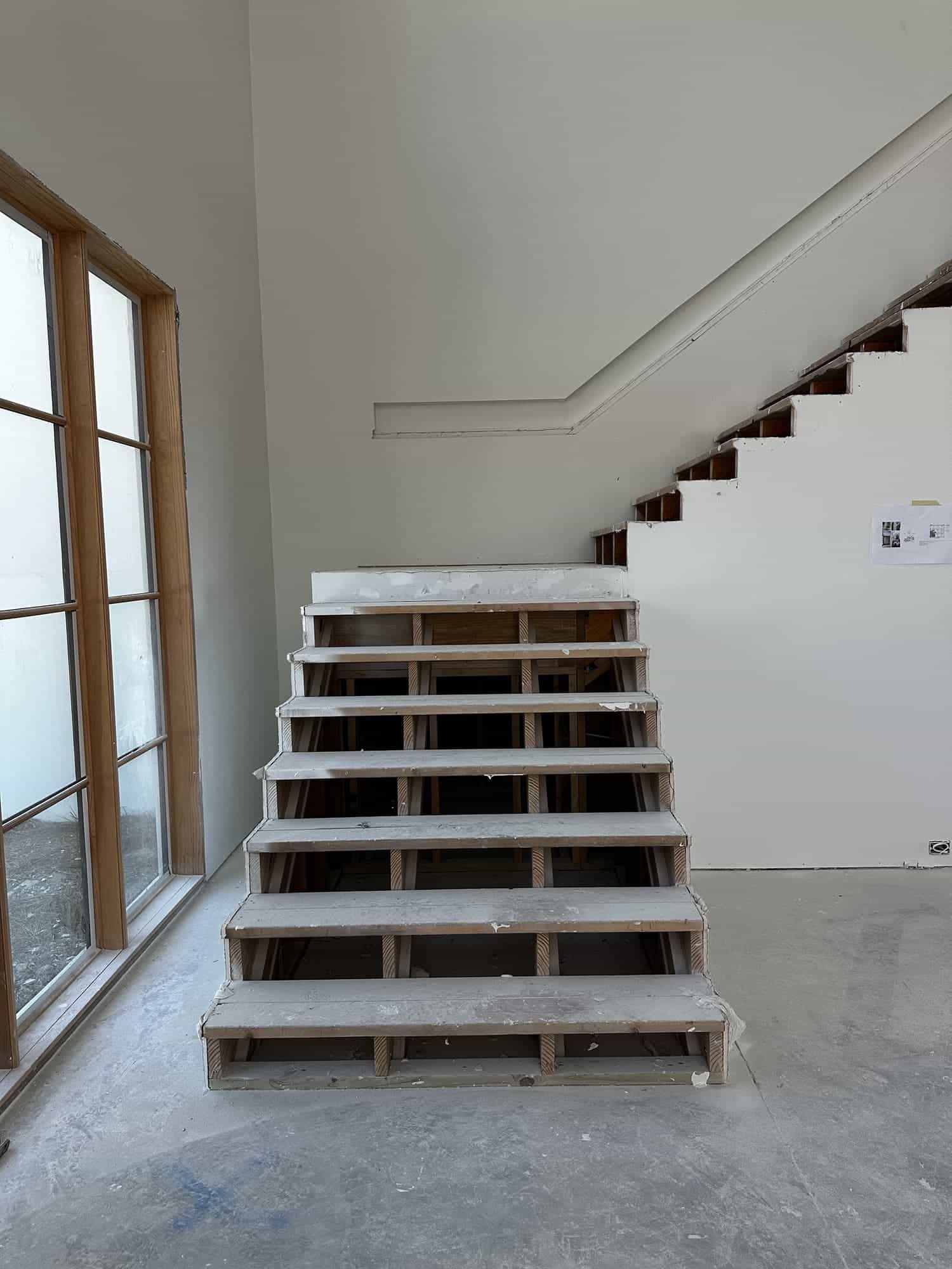 A staircase is being built in a room with a window.