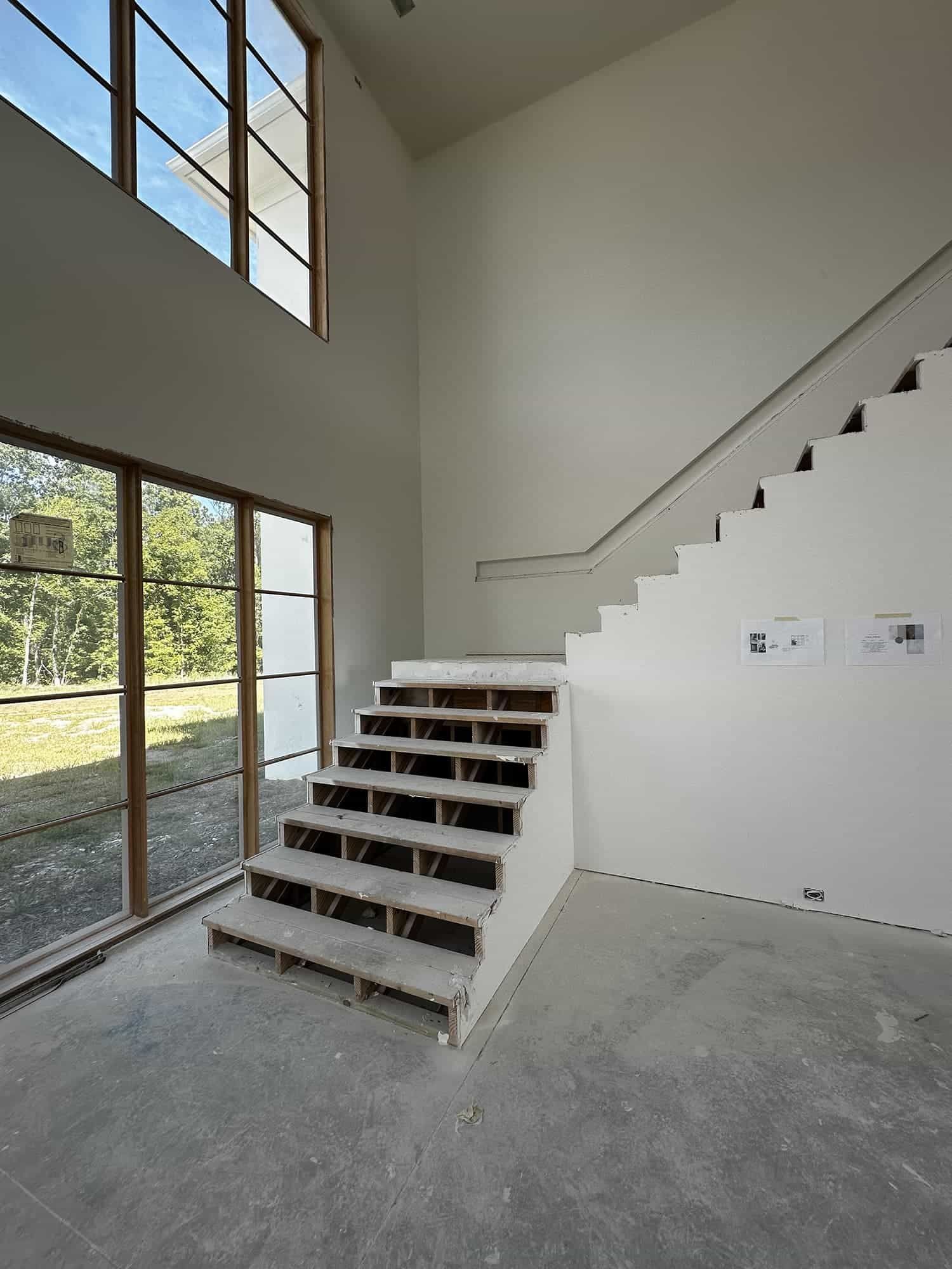 An empty room with stairs and a large window
