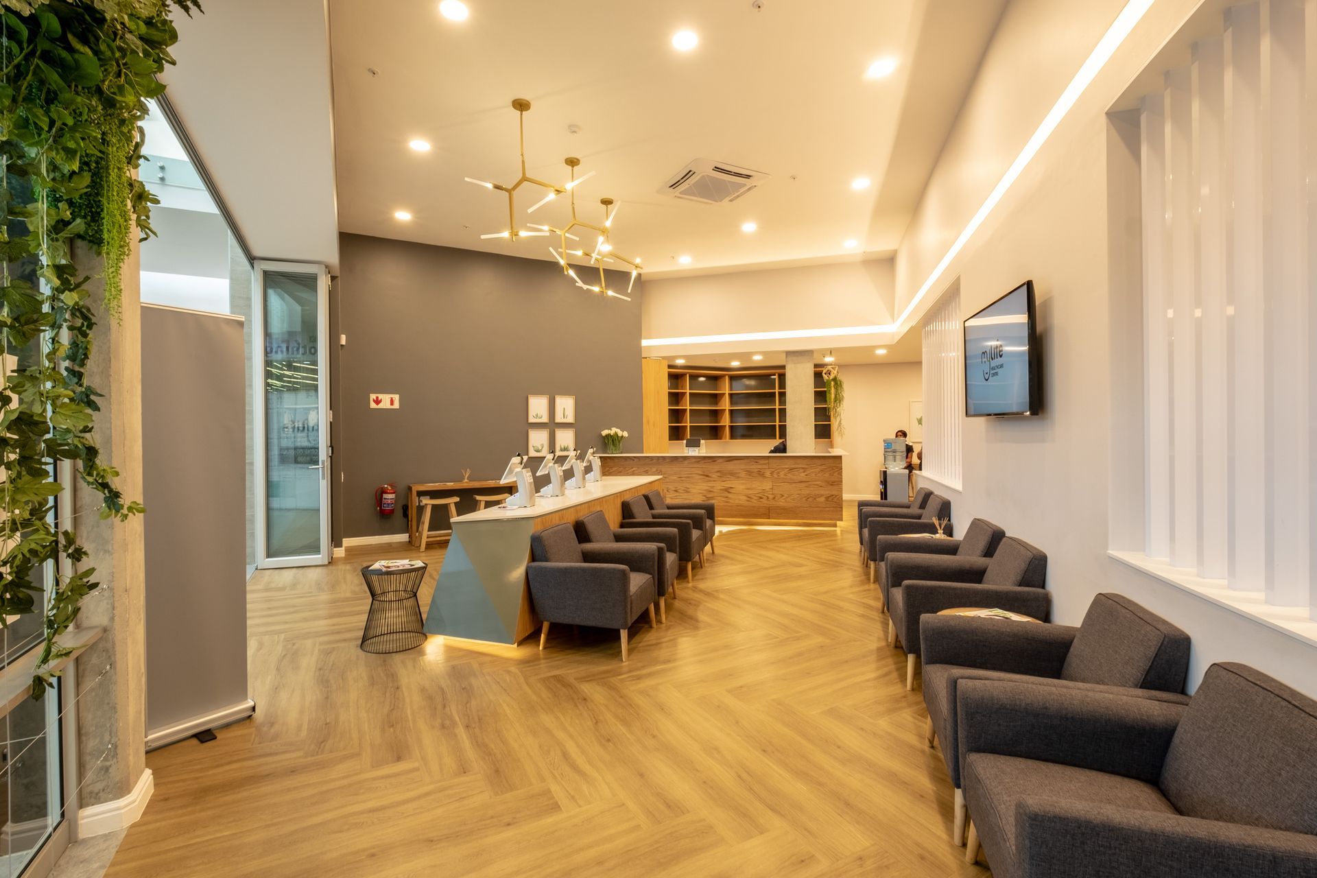 A waiting room with chairs and a television on the wall.