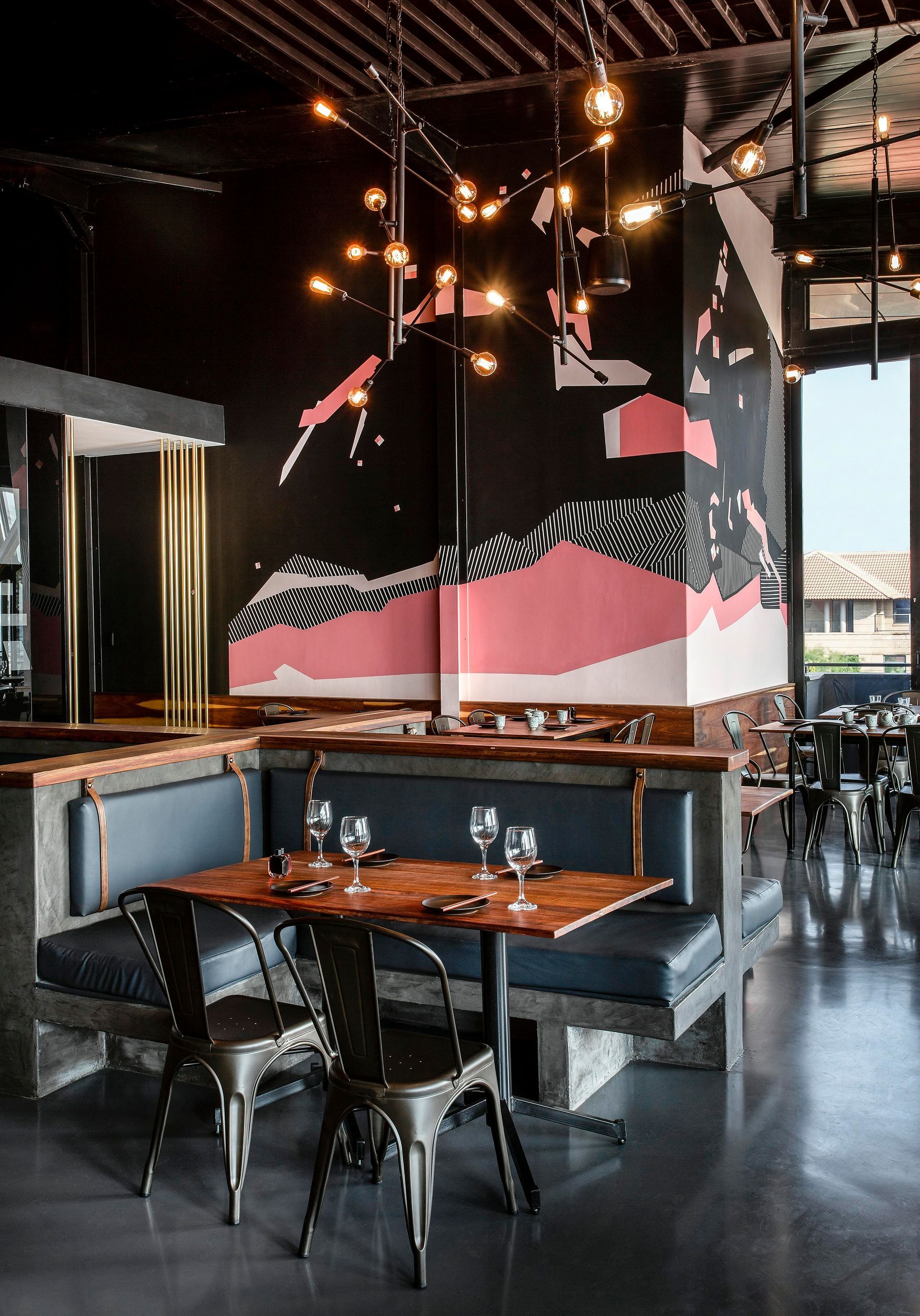 A restaurant with tables and chairs and a mural on the wall.