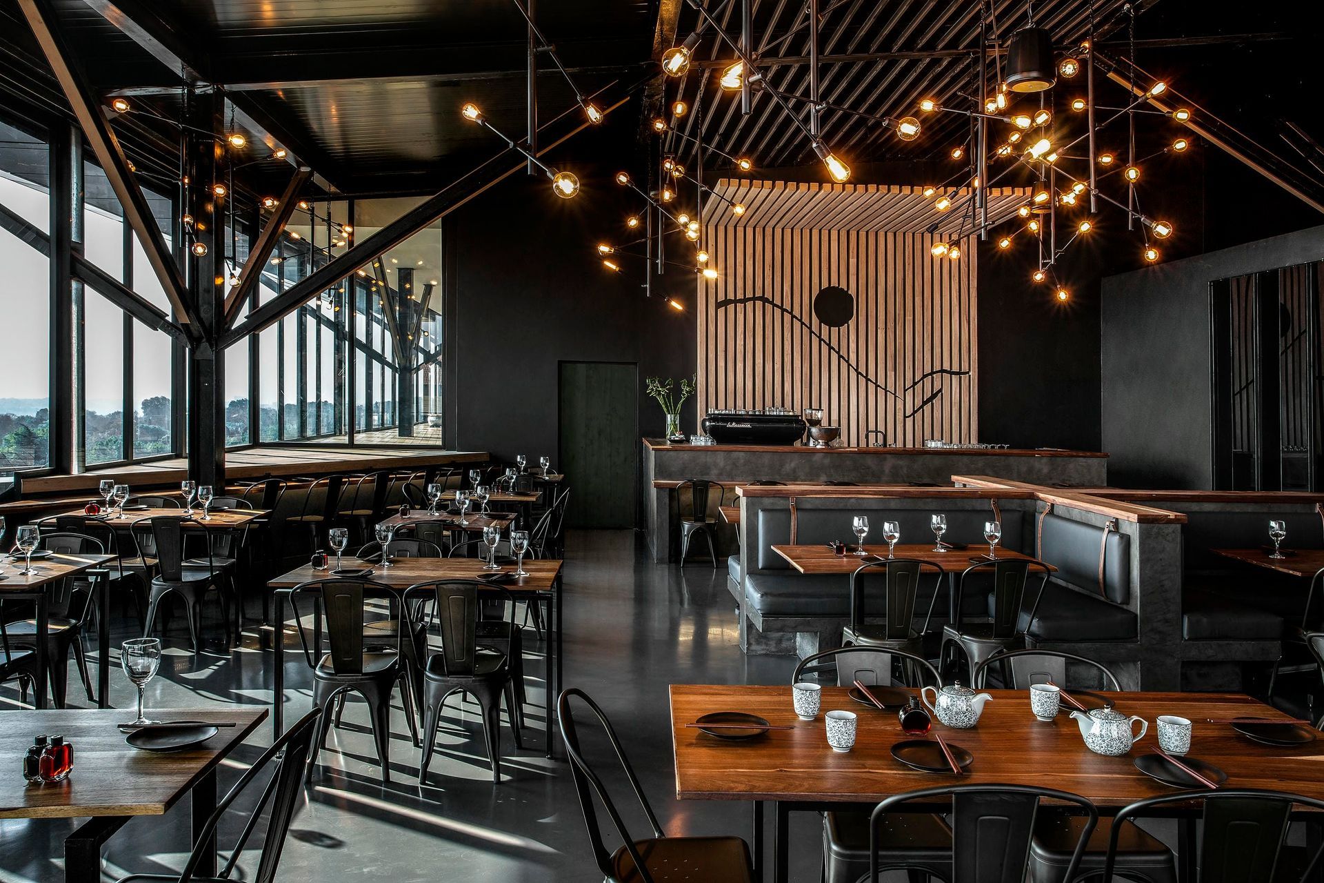 A restaurant with a lot of tables and chairs and a lot of windows.