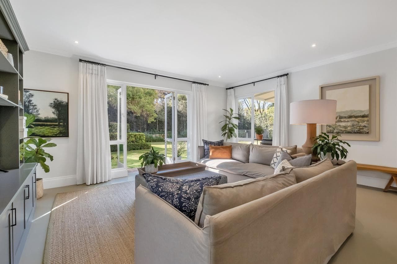 A living room with a couch , chair , coffee table , fireplace and television.