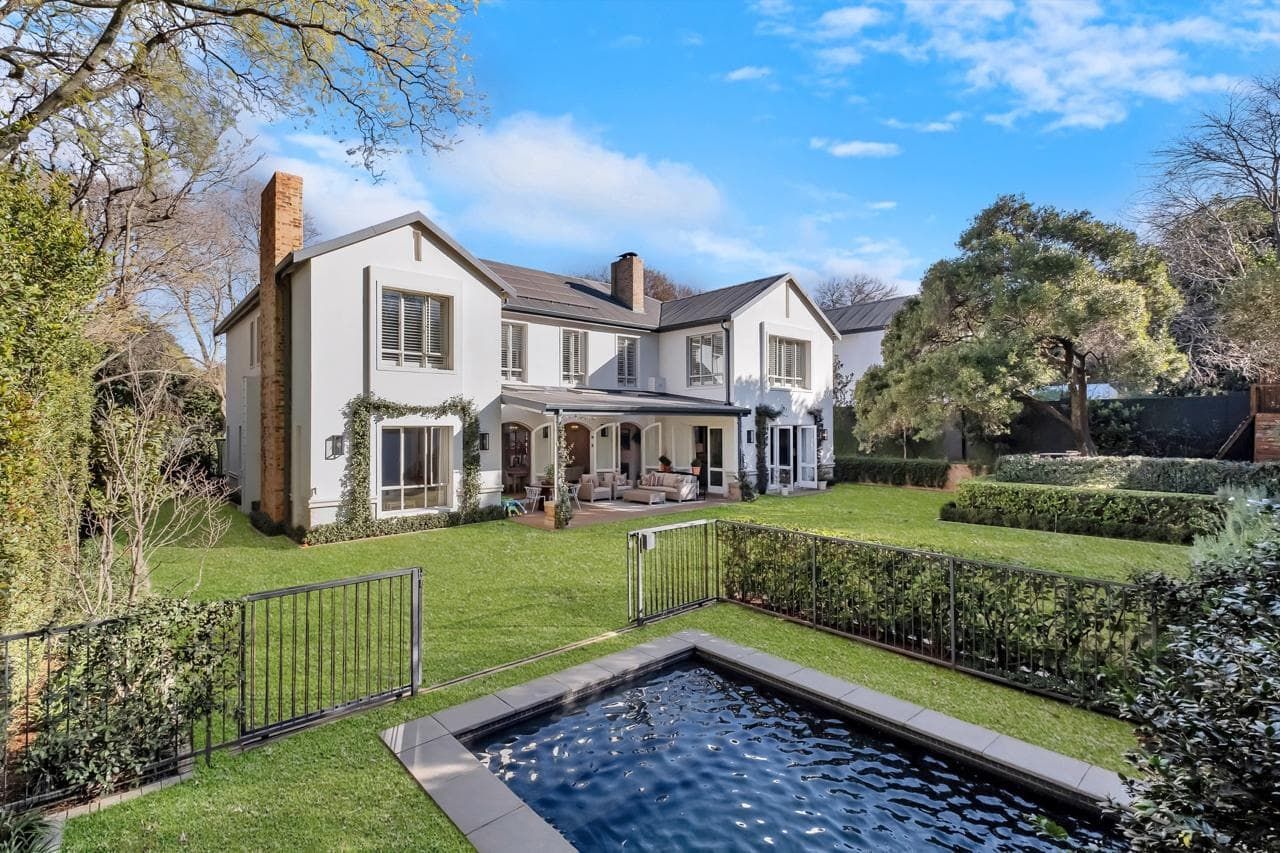 A kitchen with white cabinets , stainless steel appliances , and a large island.