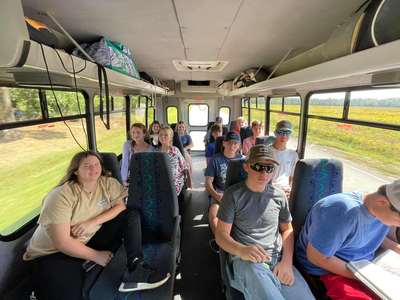 A group of people are sitting on the back of a bus.