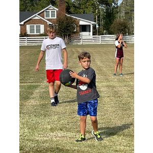 Two young boys are playing with a ball in a field.