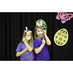 Two young girls wearing bunny ears and mustaches pose for a picture