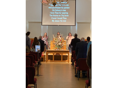 A group of people are sitting in a church watching a service.