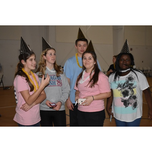 A group of young people wearing party hats and necklaces