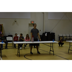 A man is standing in front of a table with cups on it