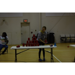 A woman stands in front of a table full of red cups