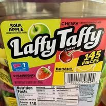 Close-up of a Laffy Taffy candy container, showcasing four flavors: sour apple, cherry, banana, and strawberry.