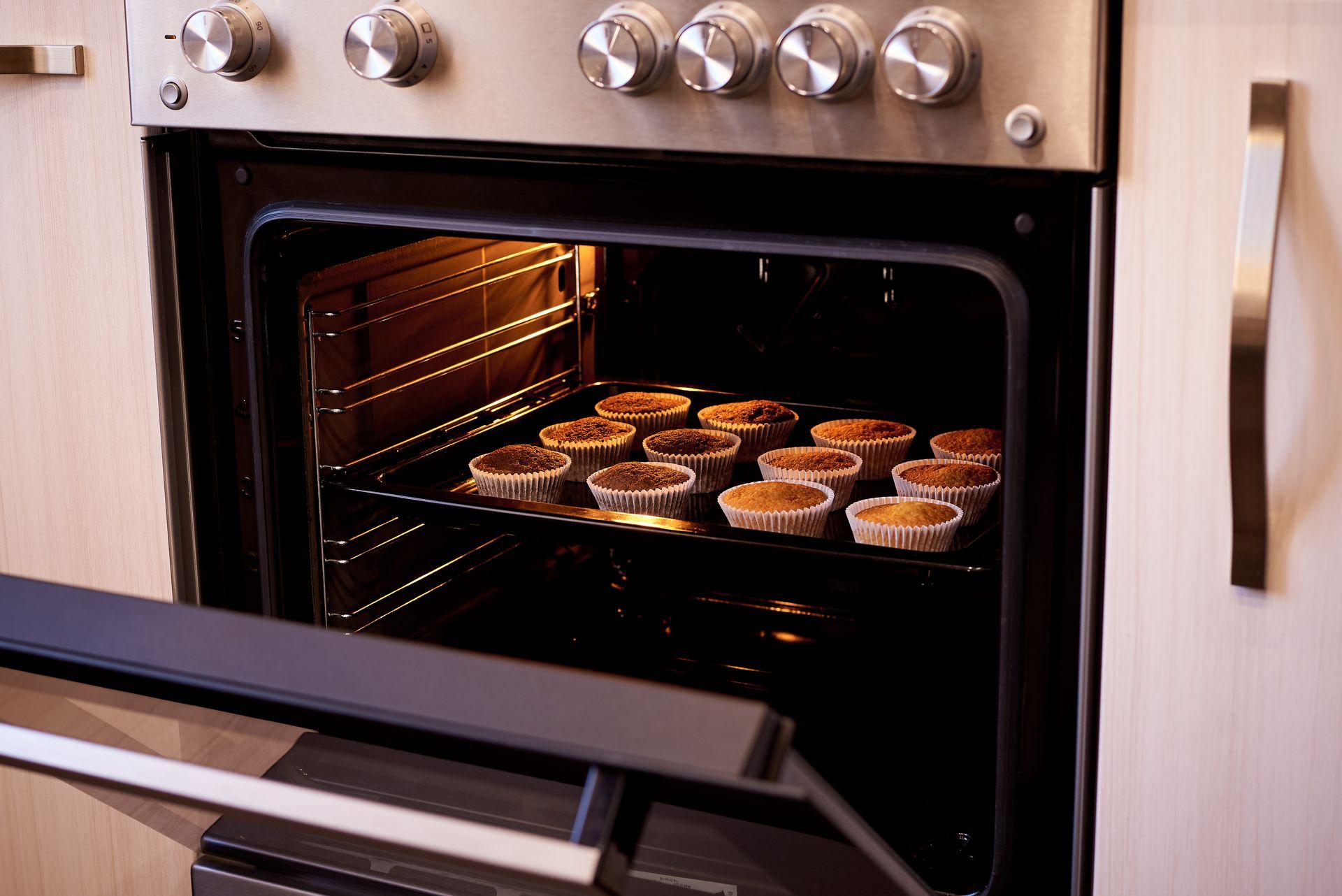 Baked cupcakes in an open oven close-up. Baked cupcakes in an open oven close-up.