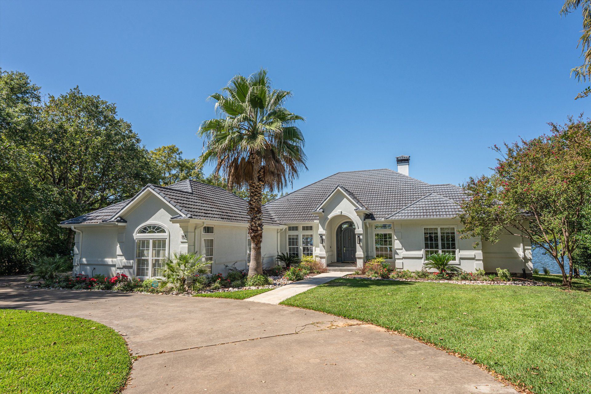 A white house with a palm tree in front of it.