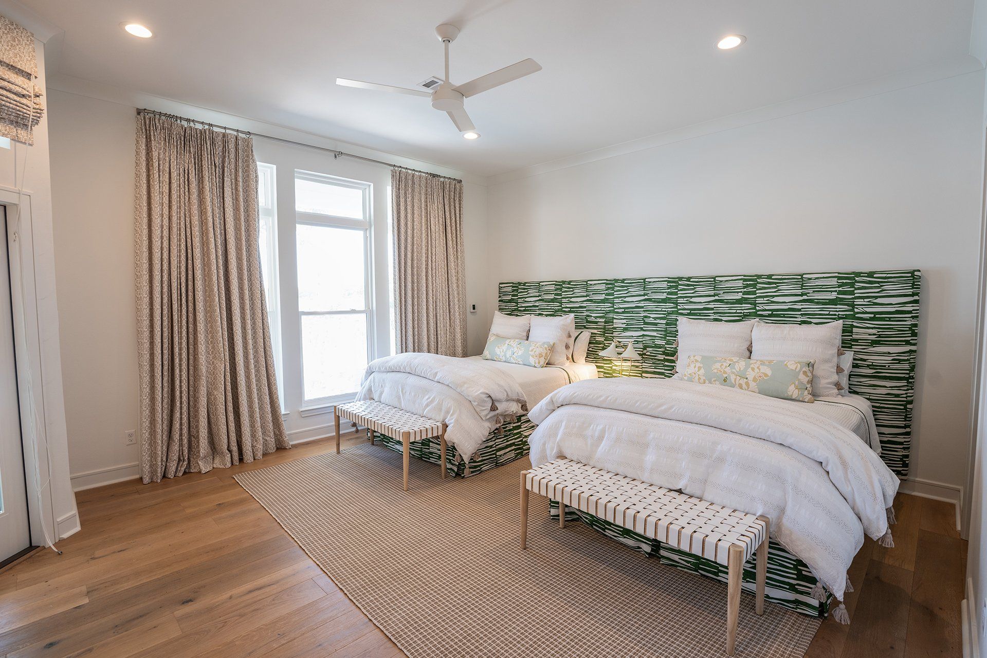 A bedroom with two beds and a ceiling fan.