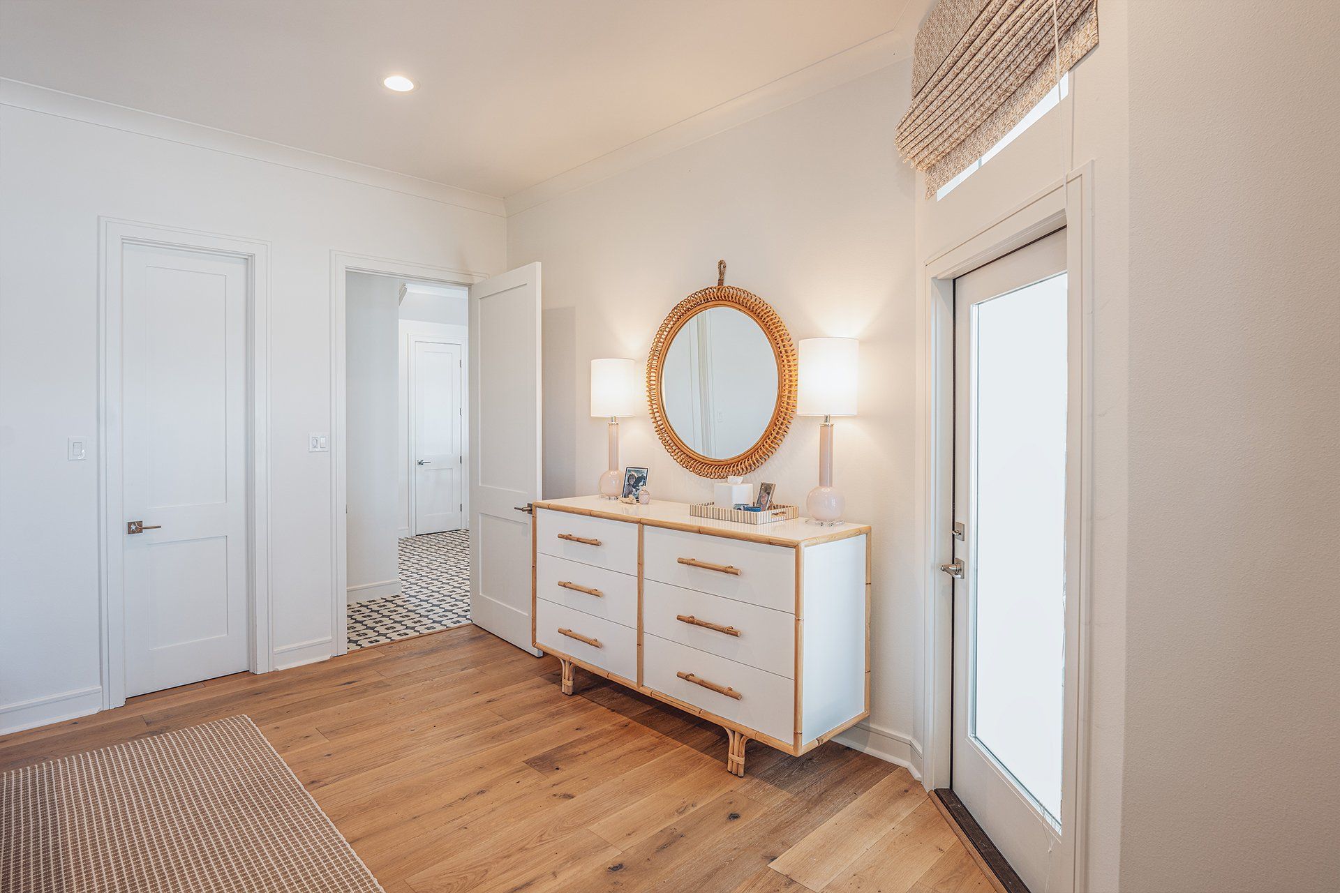 A hallway with a dresser and a mirror in a house.