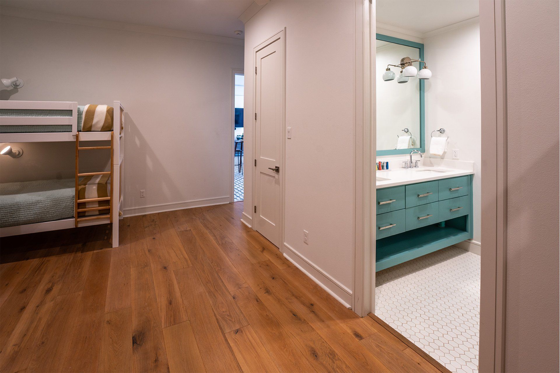 A bedroom with bunk beds and a bathroom with a sink.