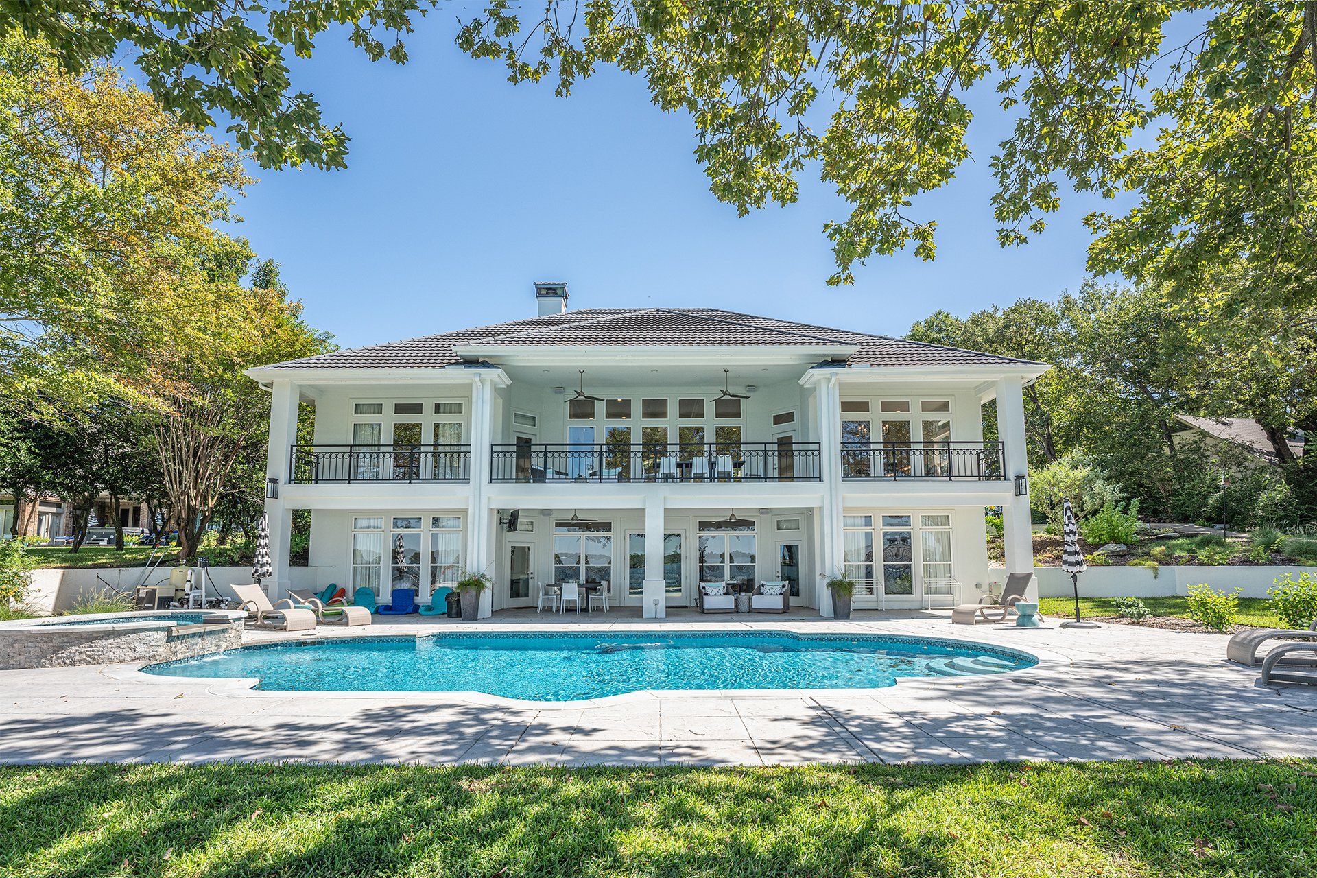 A large white house with a large swimming pool in front of it