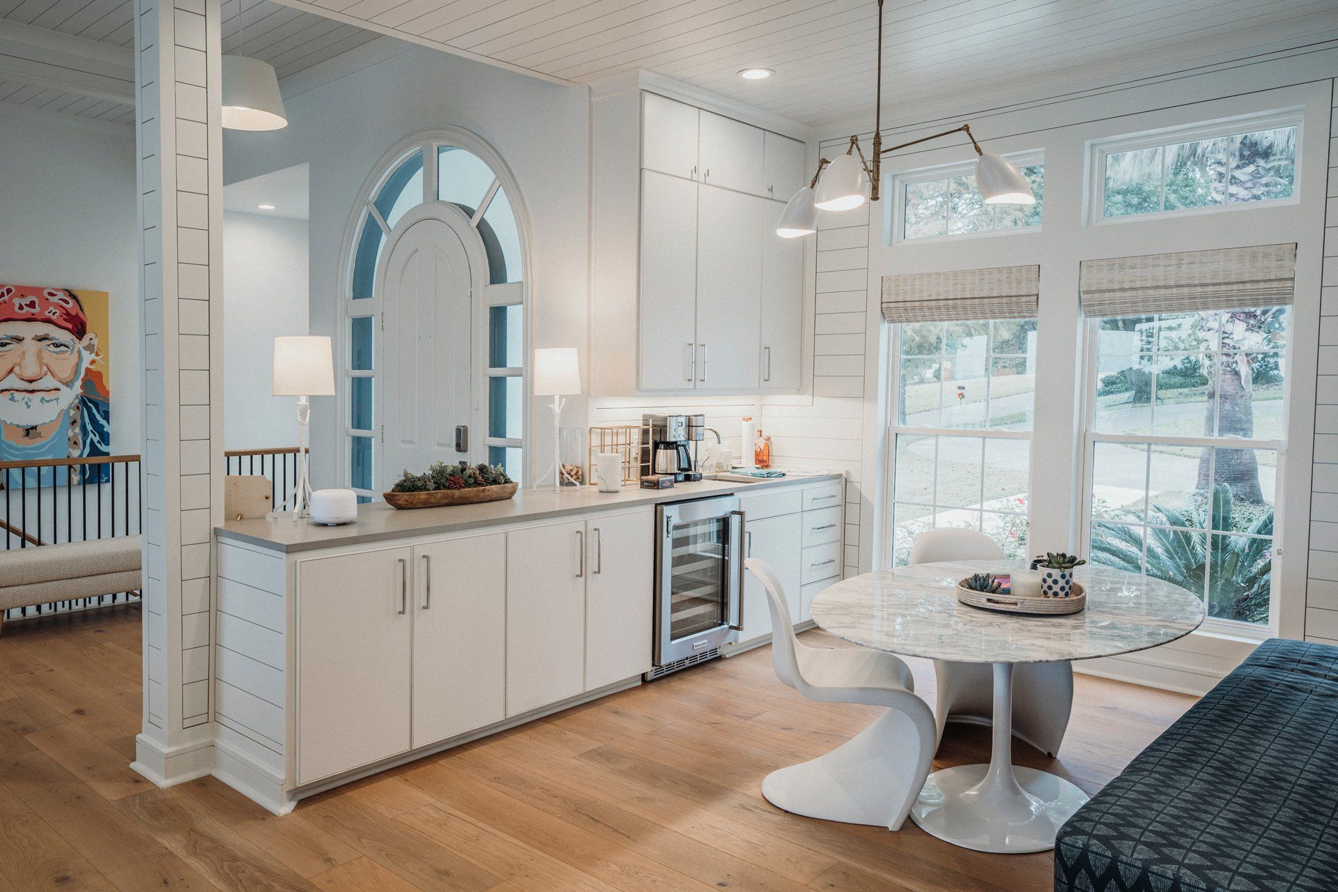 A kitchen with white cabinets , a round table and chairs.