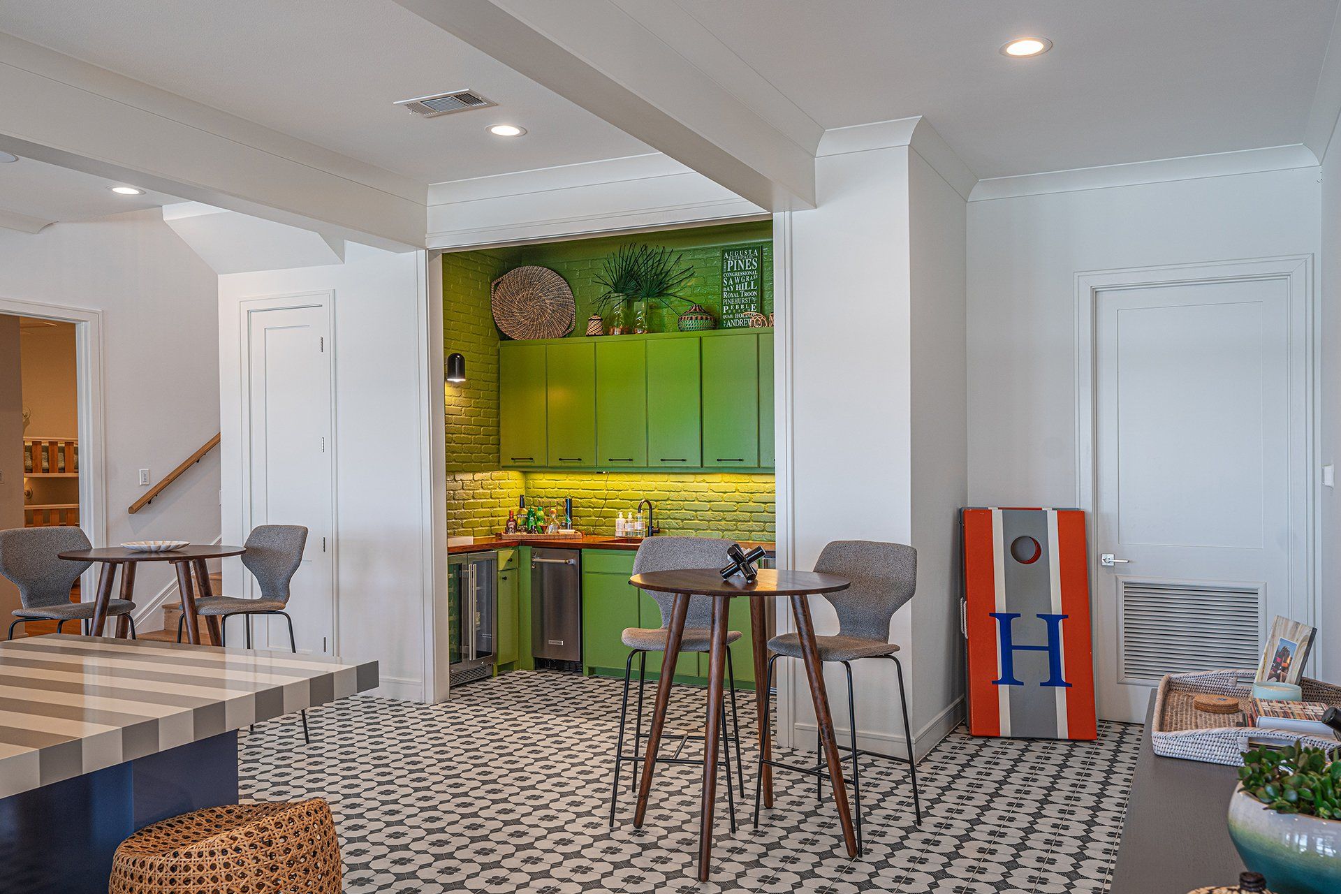 A living room with green cabinets , tables and chairs.
