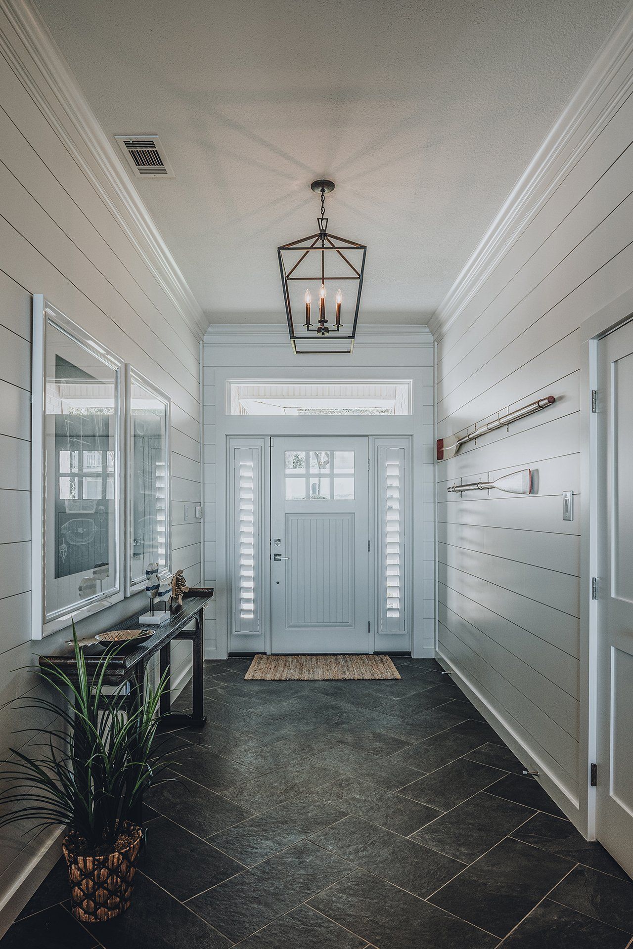 A hallway with a blue door and a lantern hanging from the ceiling.