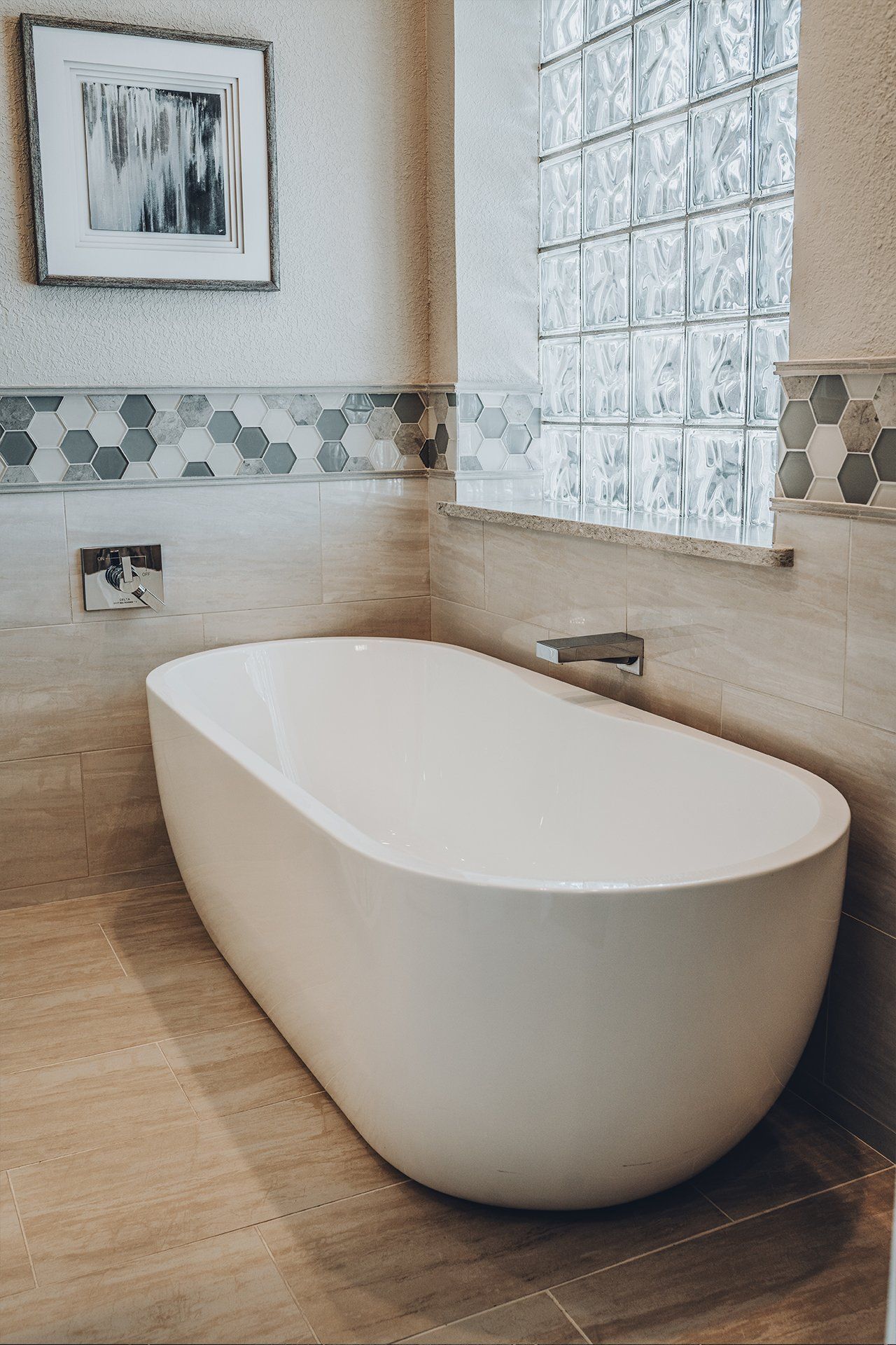A white bathtub is sitting in a bathroom next to a window.
