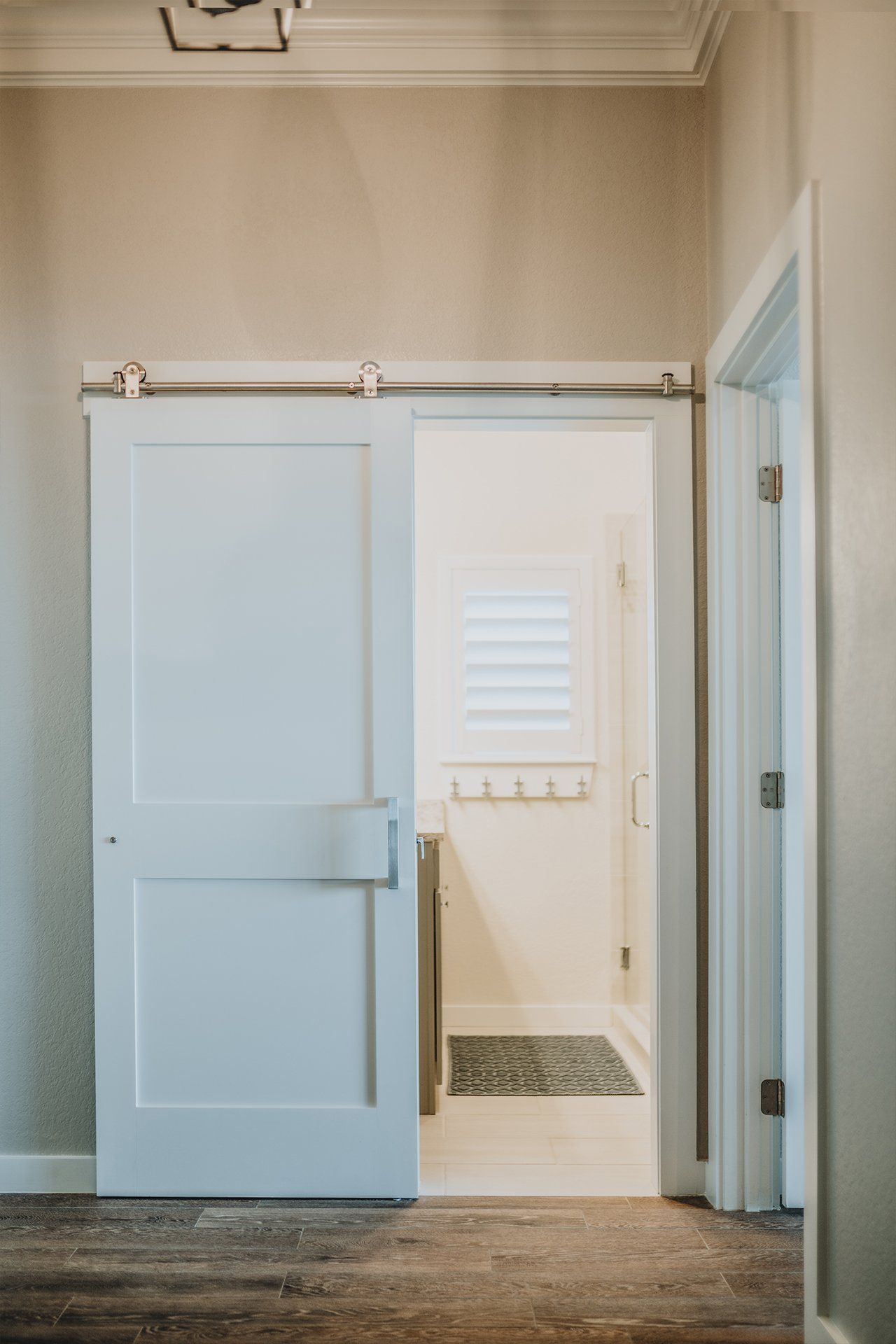 A white sliding barn door is open to a bathroom.