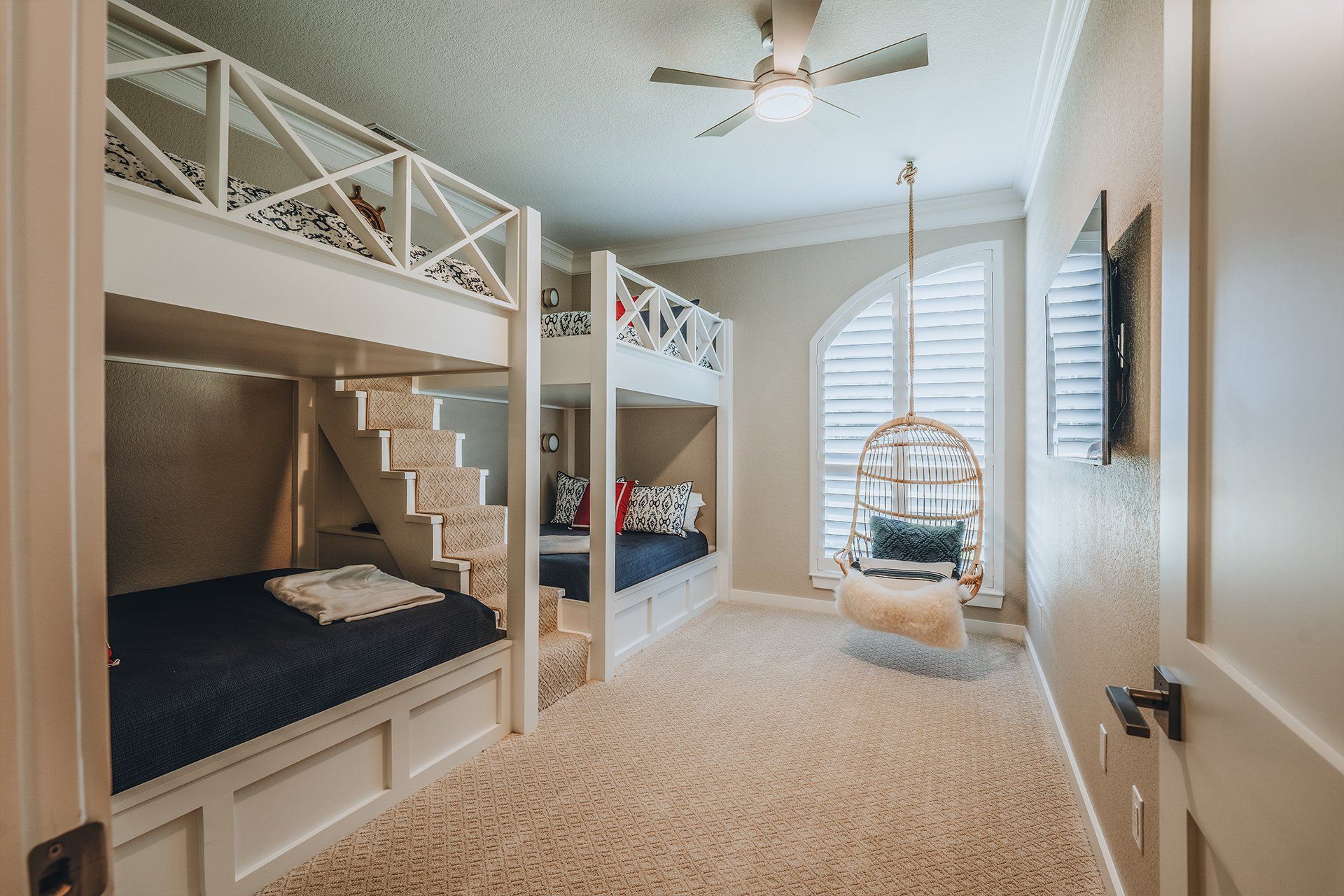 A bedroom with bunk beds and a ceiling fan.