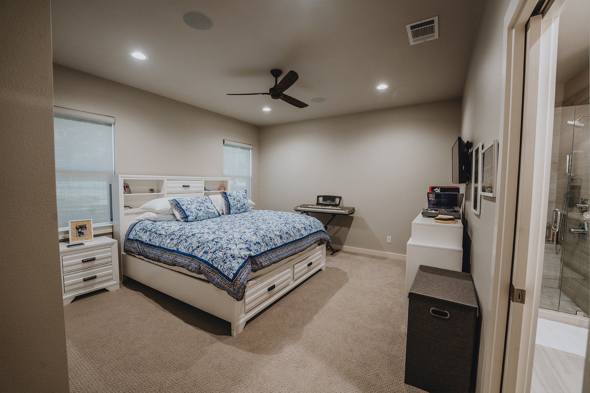A bedroom with a king size bed and a ceiling fan.