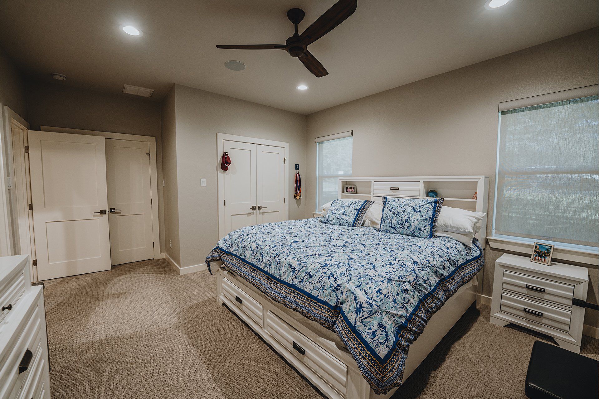 A bedroom with a king size bed and a ceiling fan.