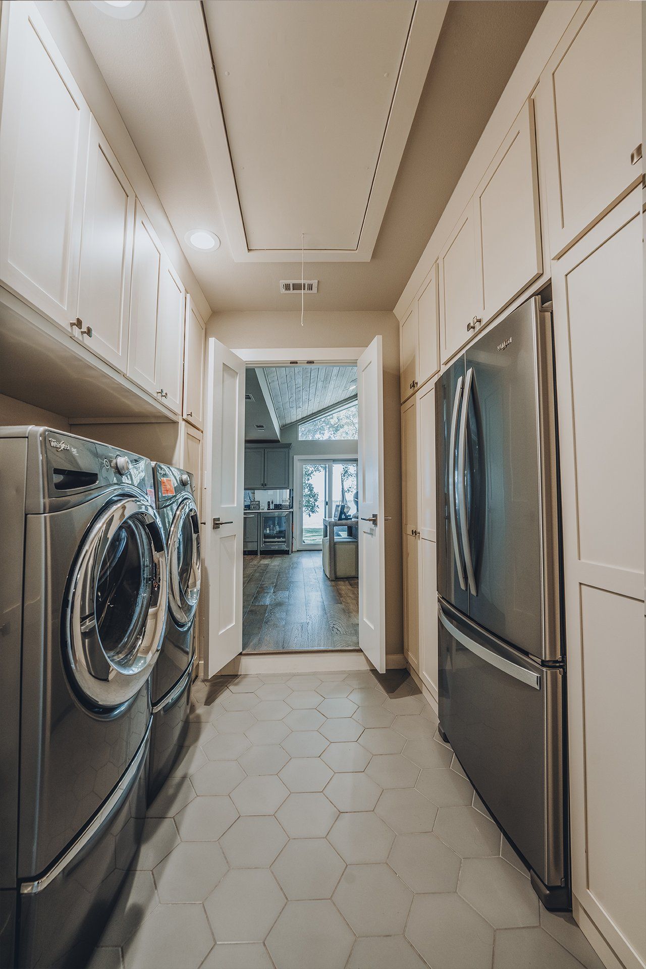 A laundry room with a washer and dryer and a refrigerator.