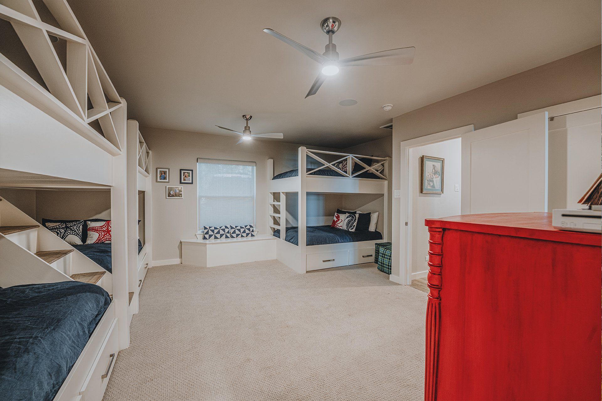 A bedroom with bunk beds and a red dresser.