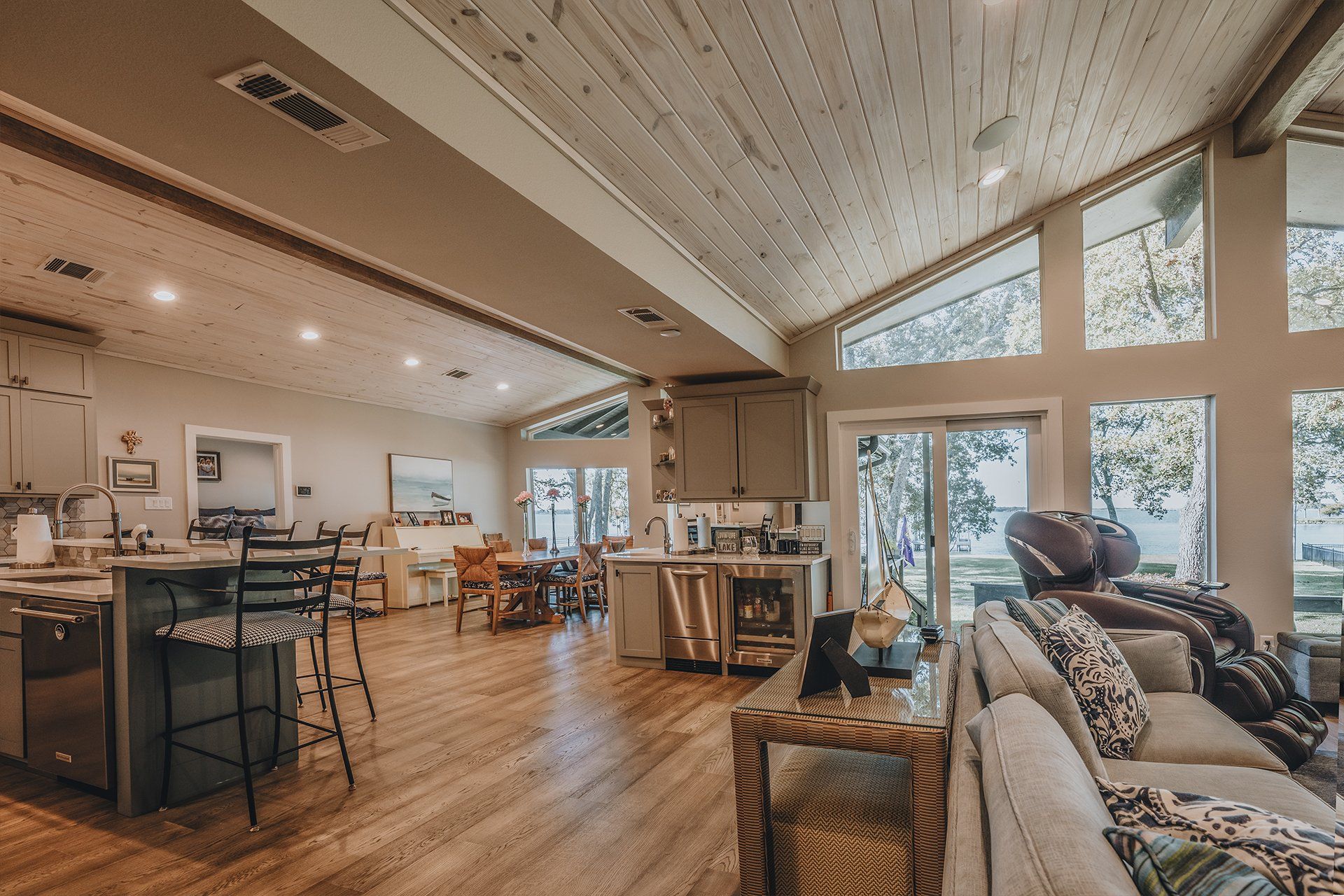 A living room filled with furniture and a kitchen with a lot of windows.