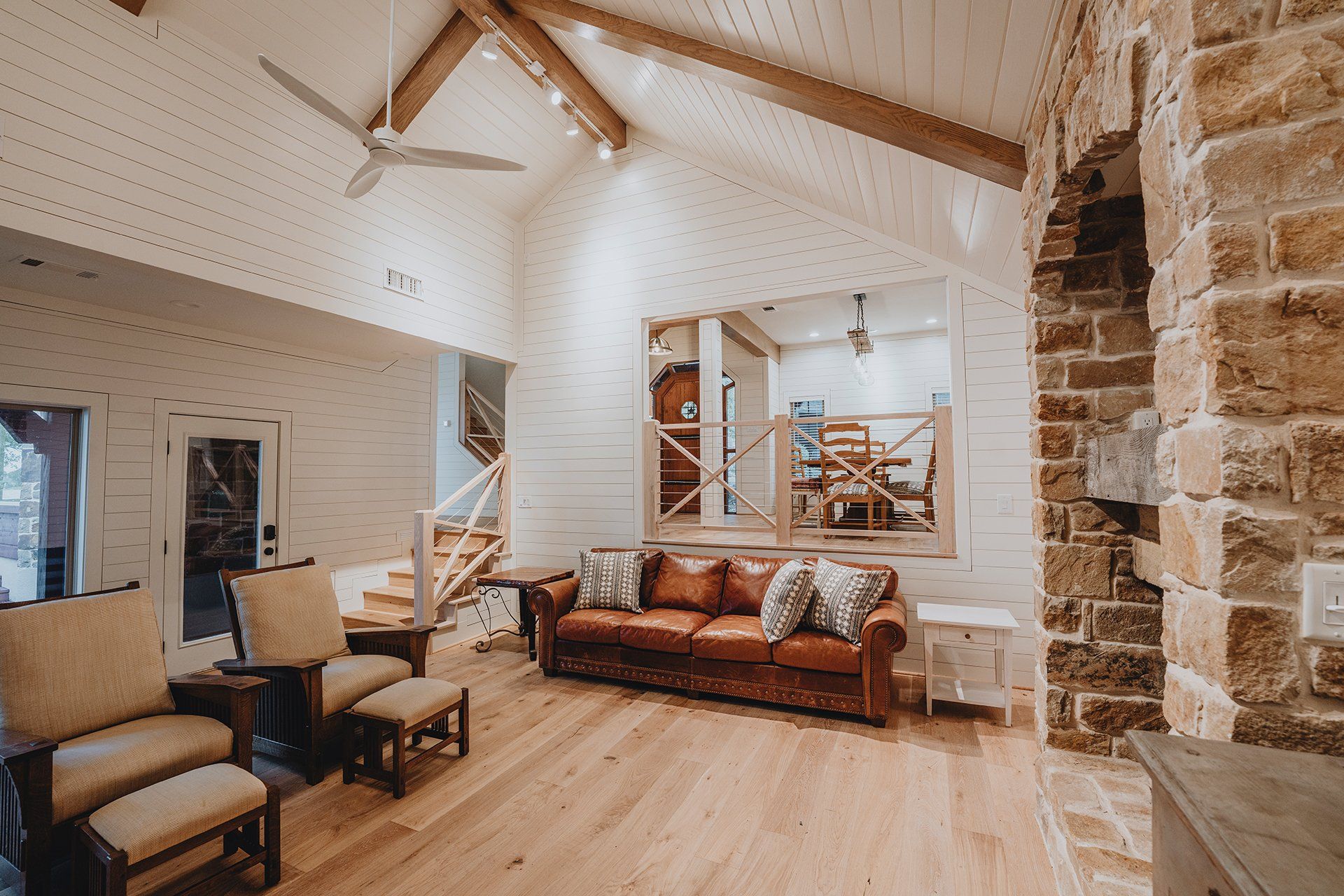 A living room with a couch , chairs , and a ceiling fan.