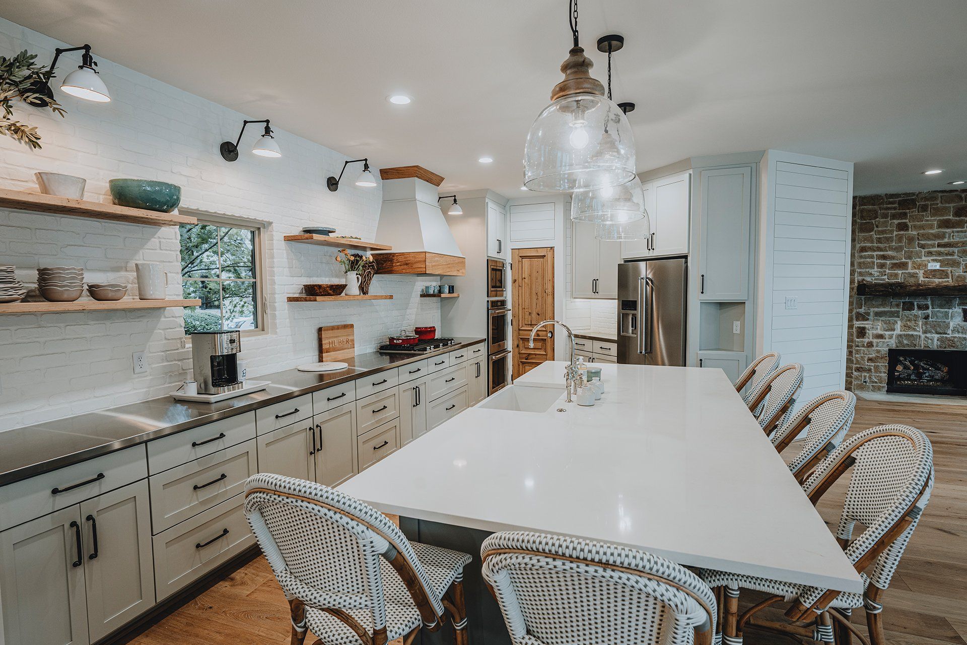 A kitchen with a long table and wicker chairs.