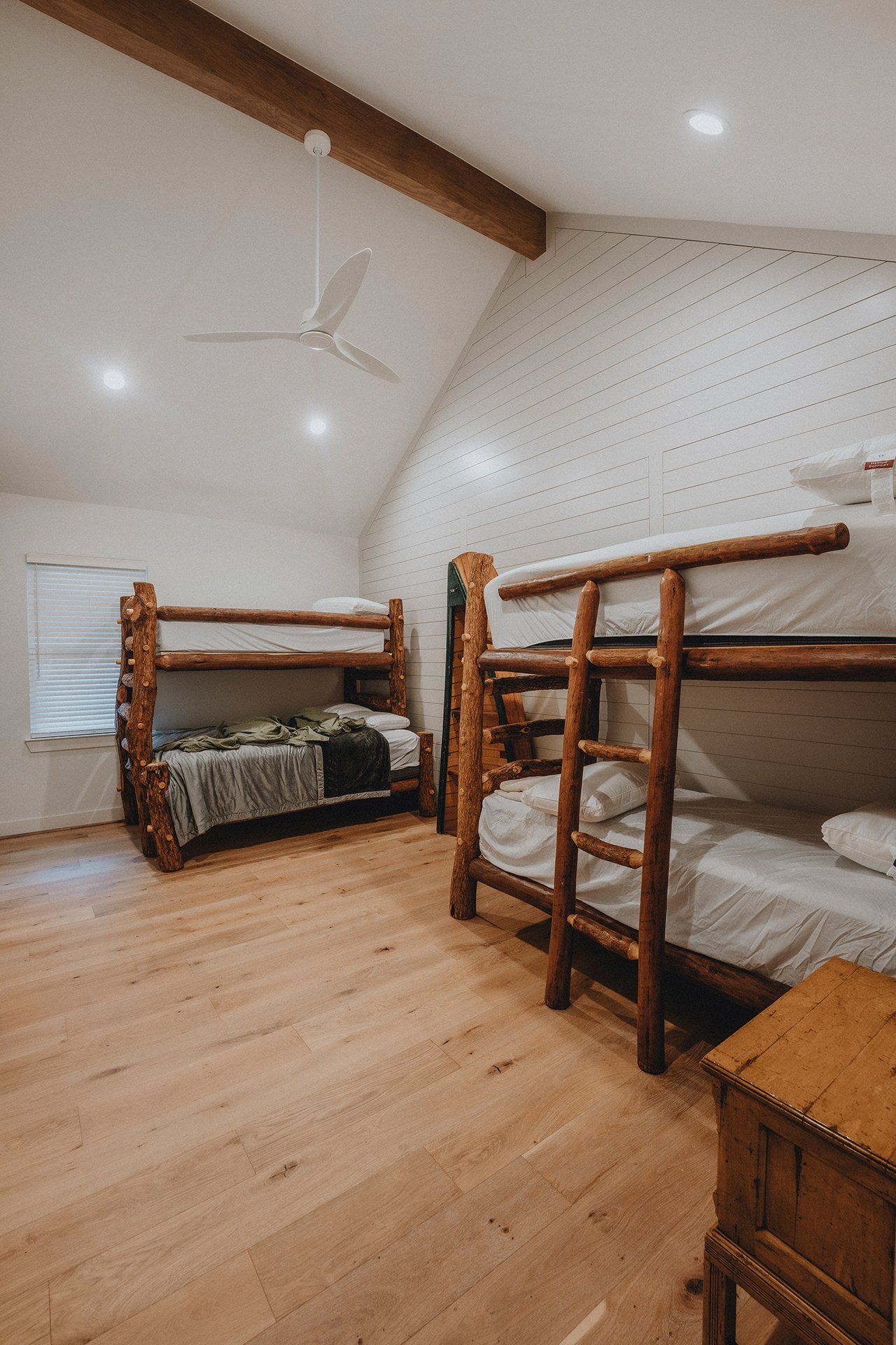 A bedroom with three bunk beds and a ceiling fan.
