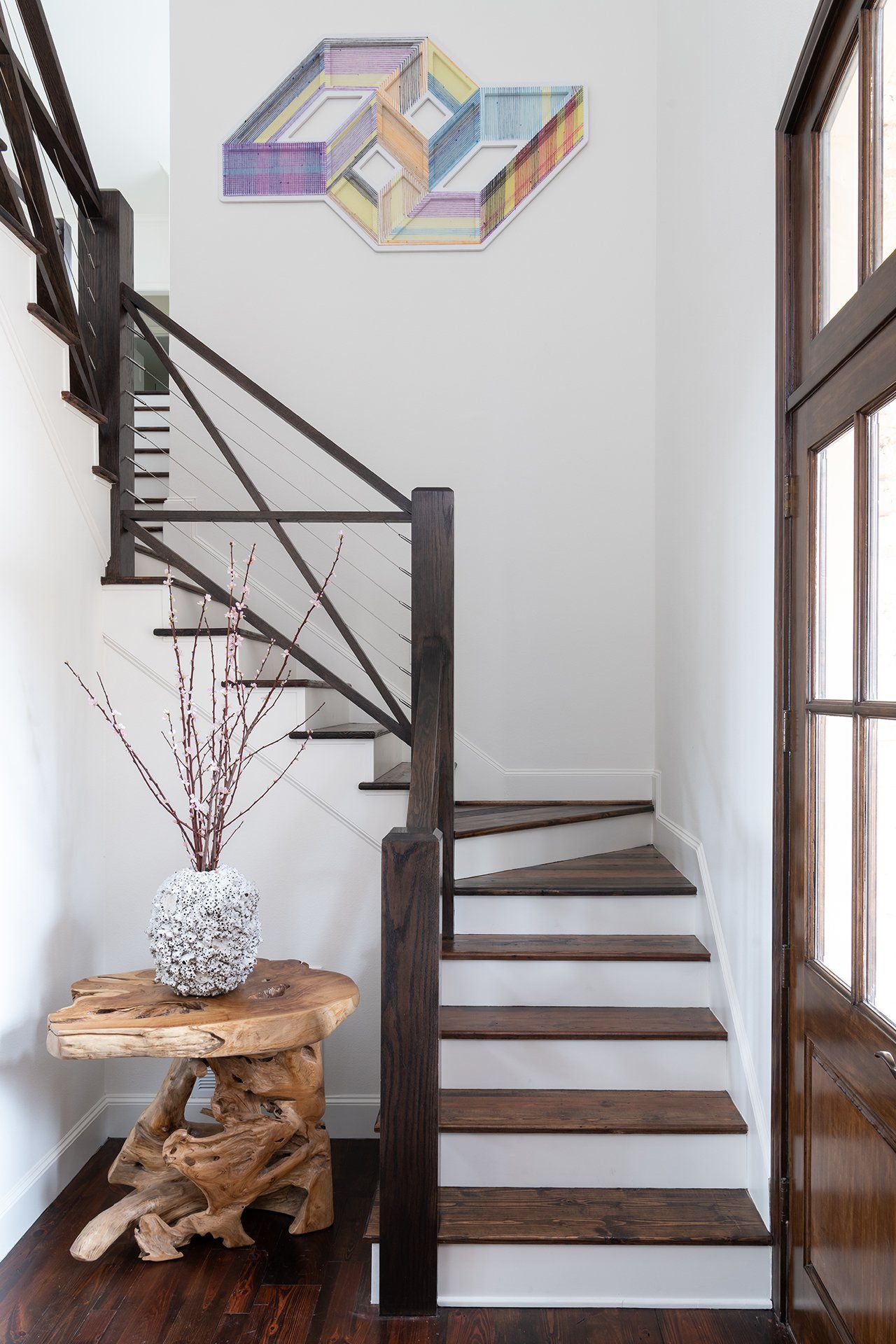 A wooden staircase with a painting on the wall above it