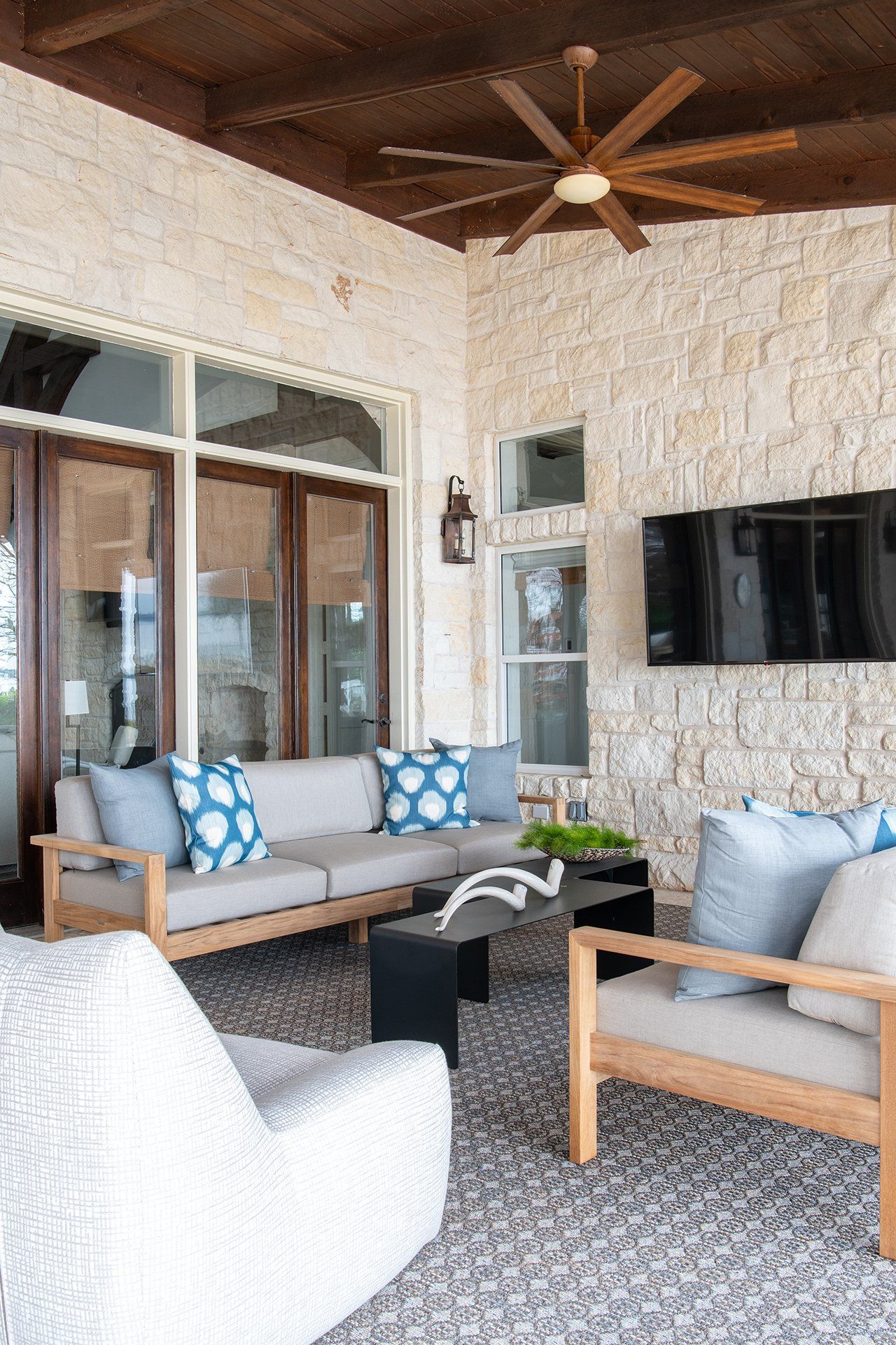 A living room with a couch , chairs , and a ceiling fan.