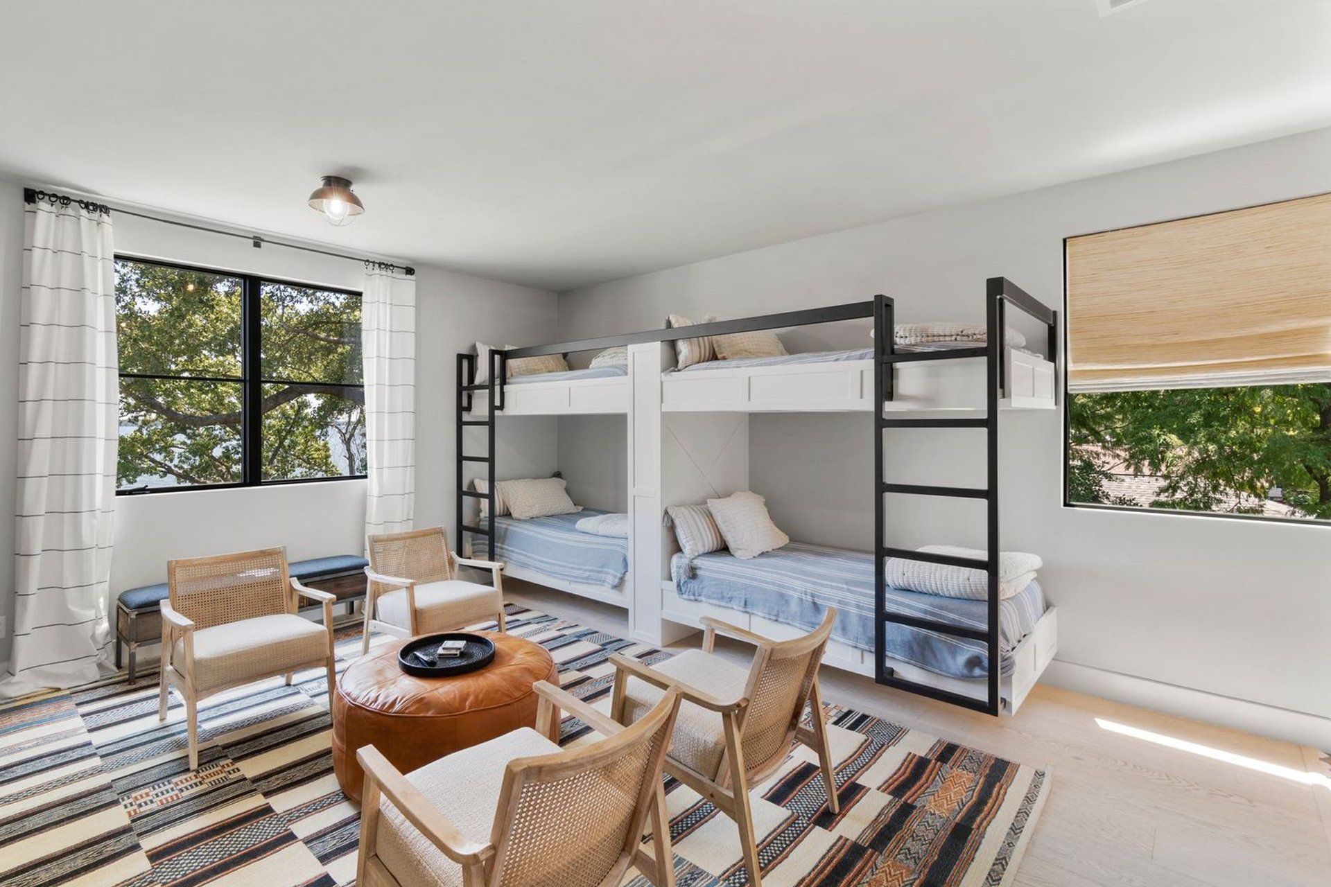 A bedroom with bunk beds , chairs , and a rug.