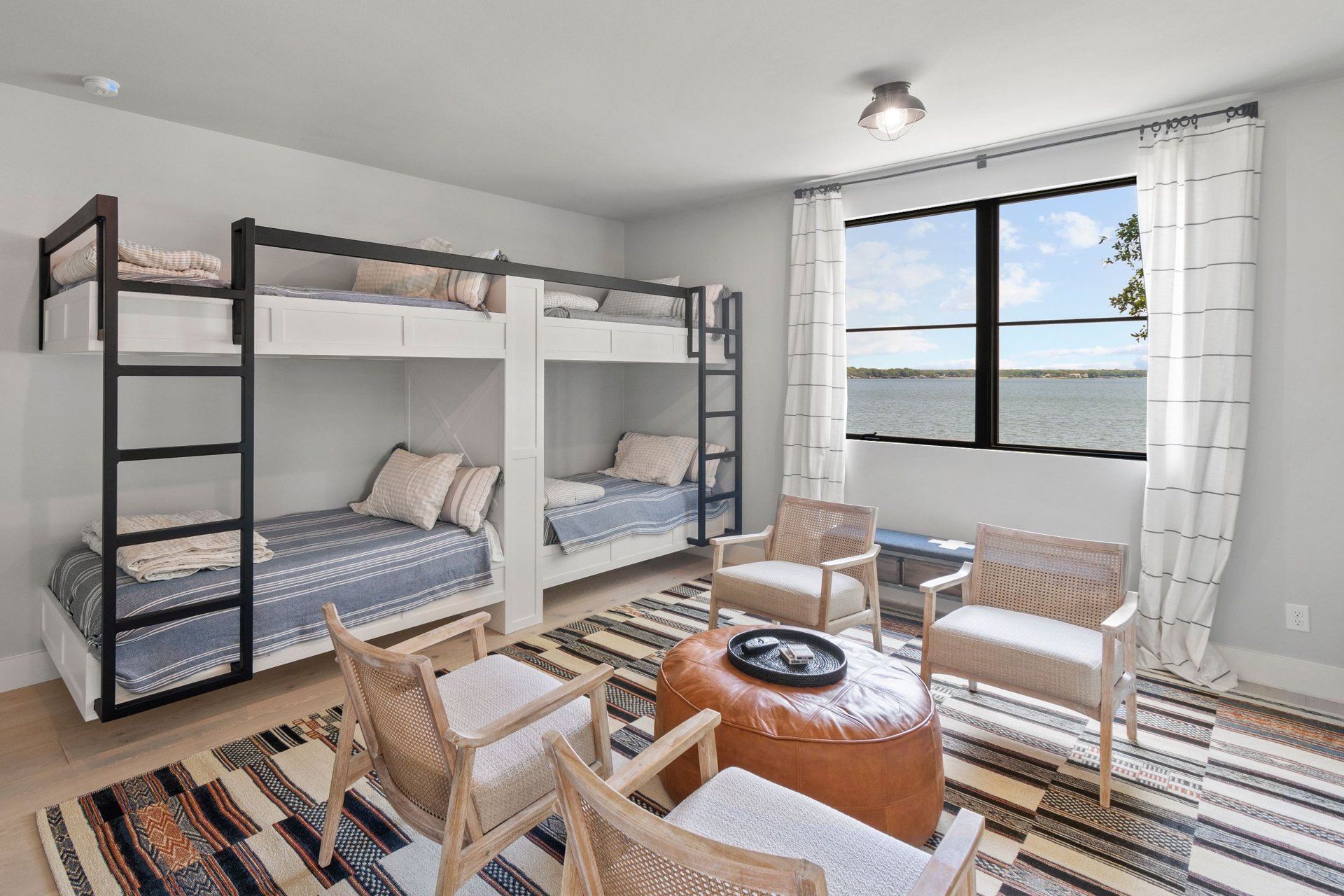 A living room with bunk beds , chairs , and a table.