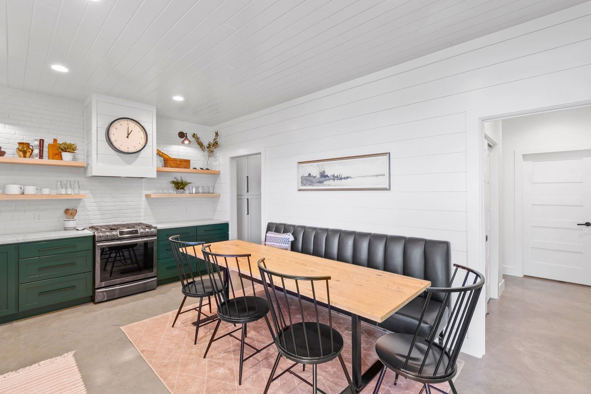 A kitchen with a table and chairs and a bench.