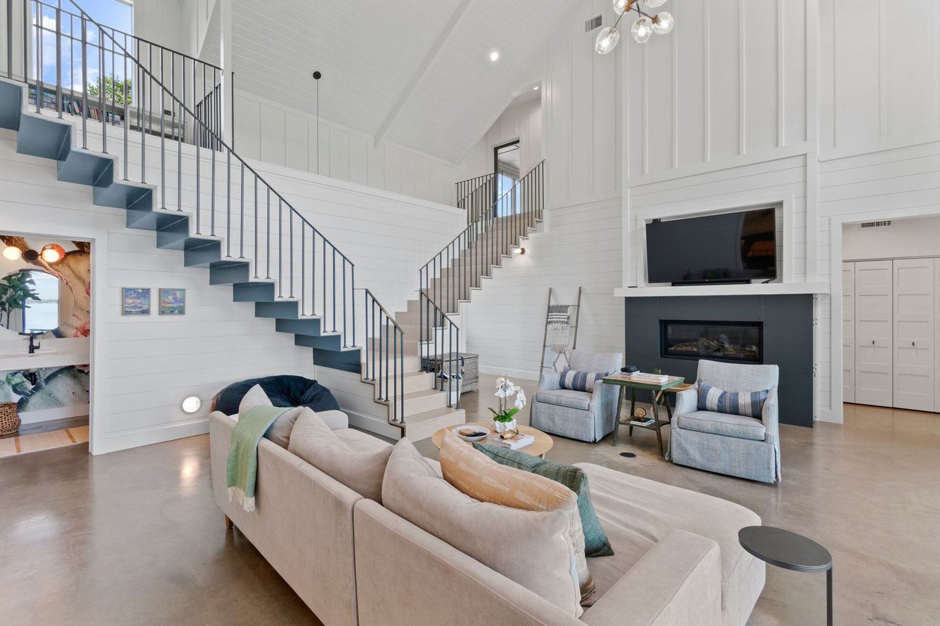 A living room with a staircase leading up to the second floor.