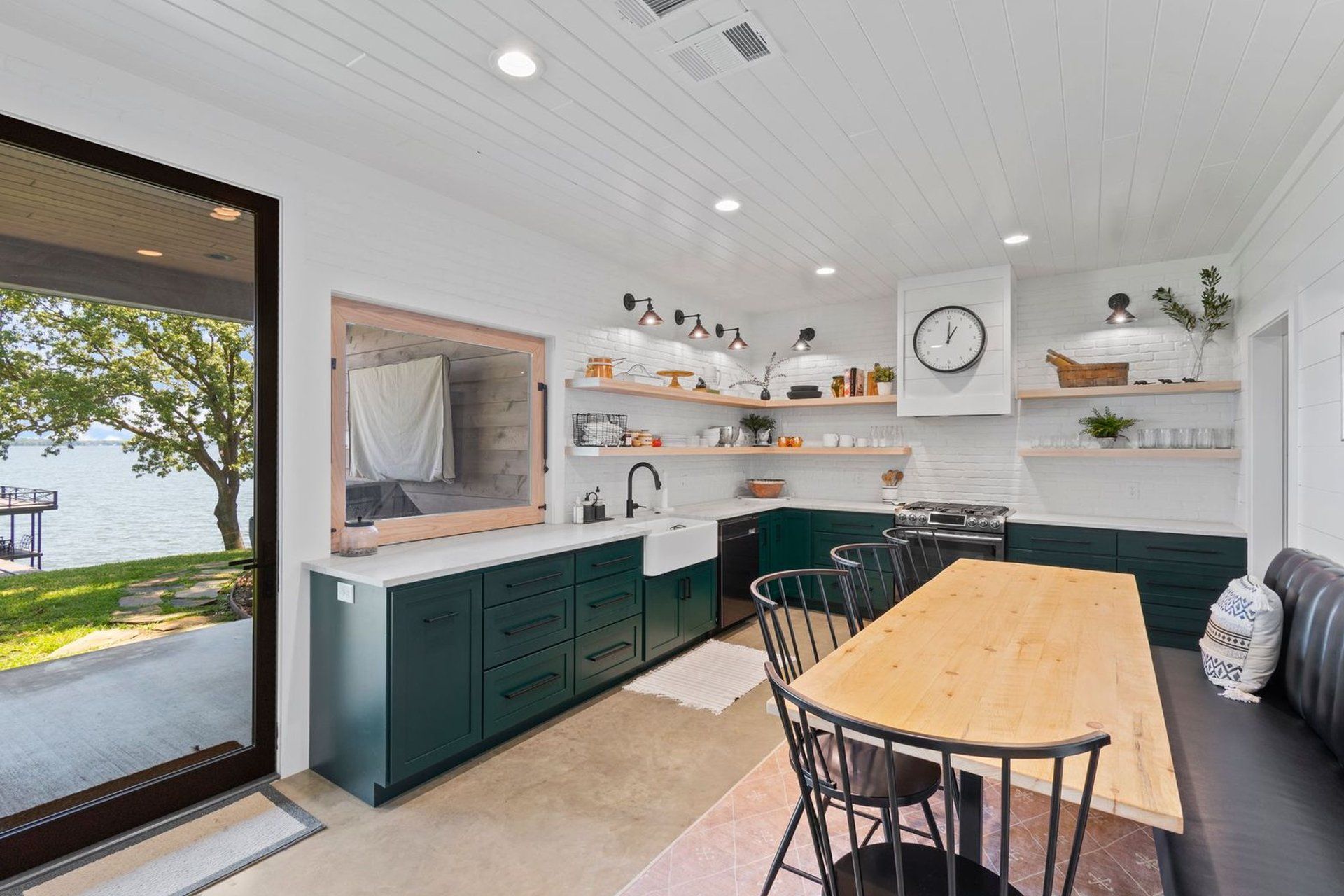 A kitchen with a table and chairs and a clock on the wall.