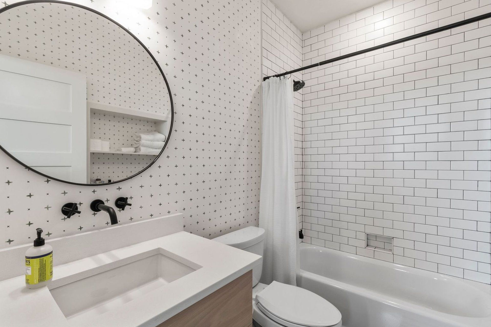 A bathroom with a sink , toilet , bathtub and mirror.