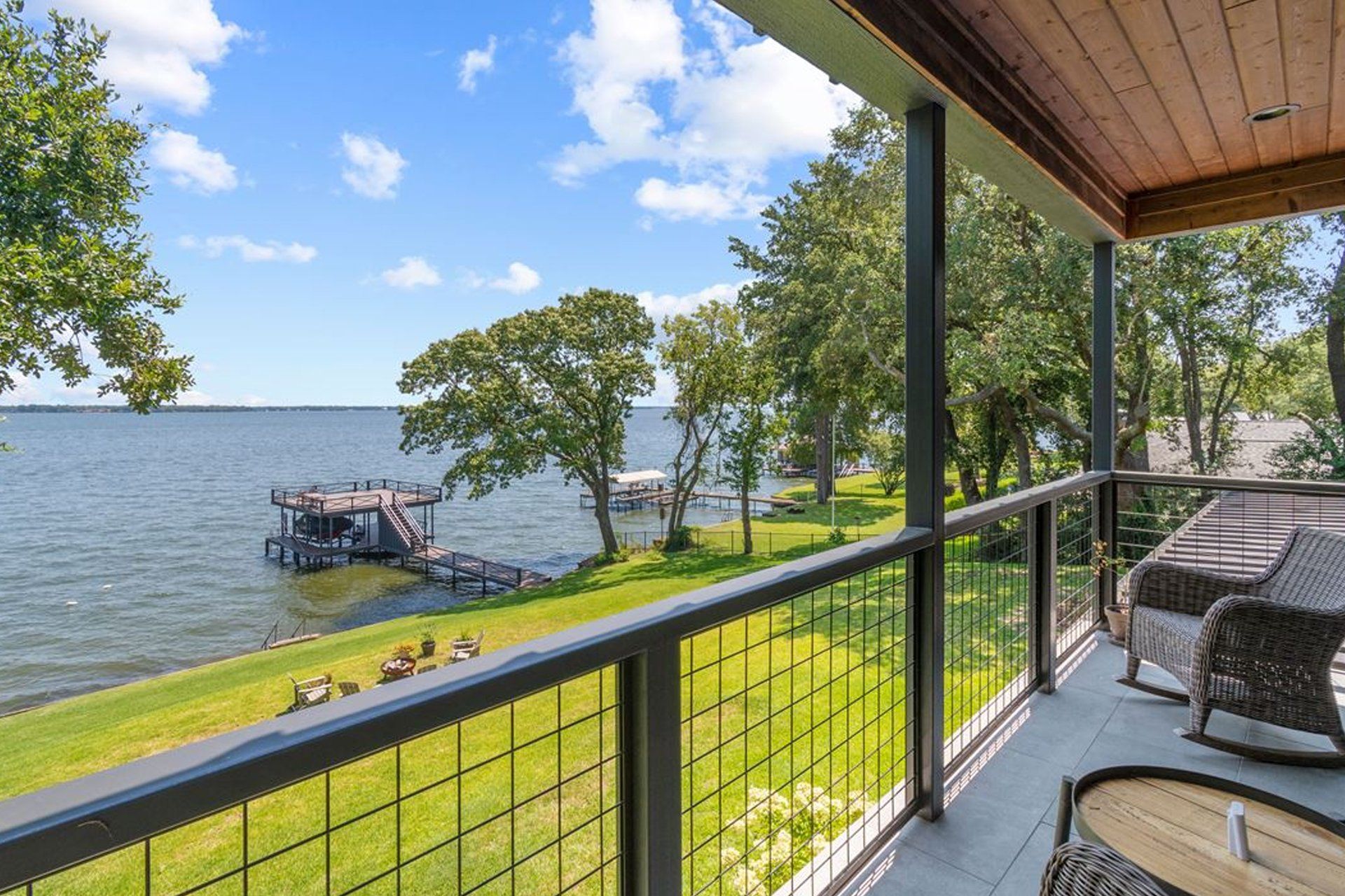 A balcony with a view of a lake and a dock.