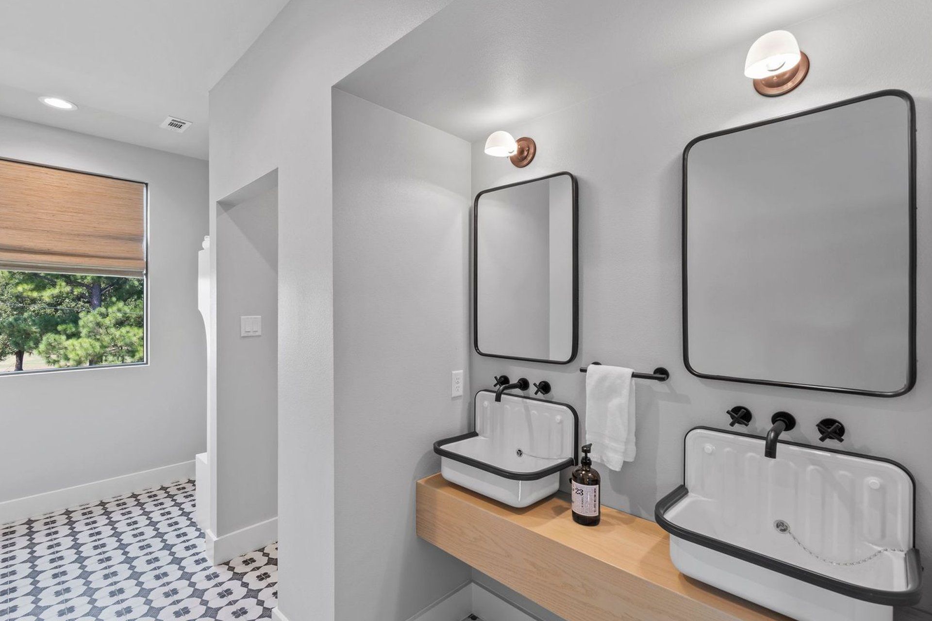 A bathroom with two sinks and two mirrors.