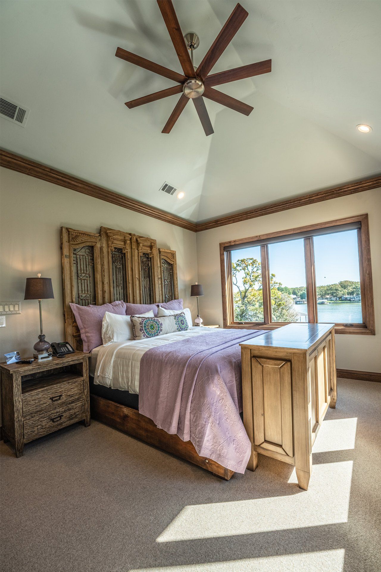 A bedroom with a large bed and a ceiling fan.