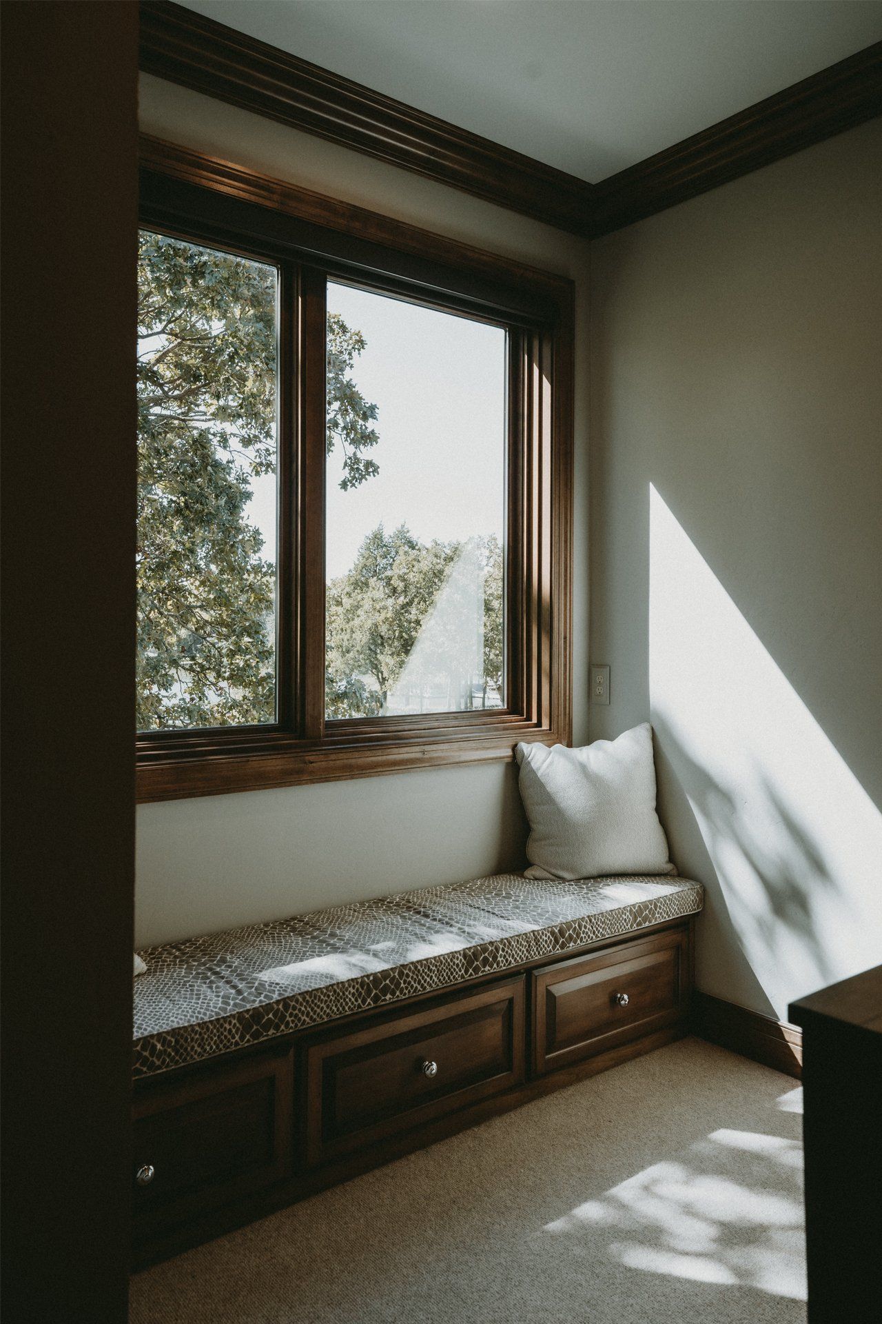 There is a window seat in the corner of the room.