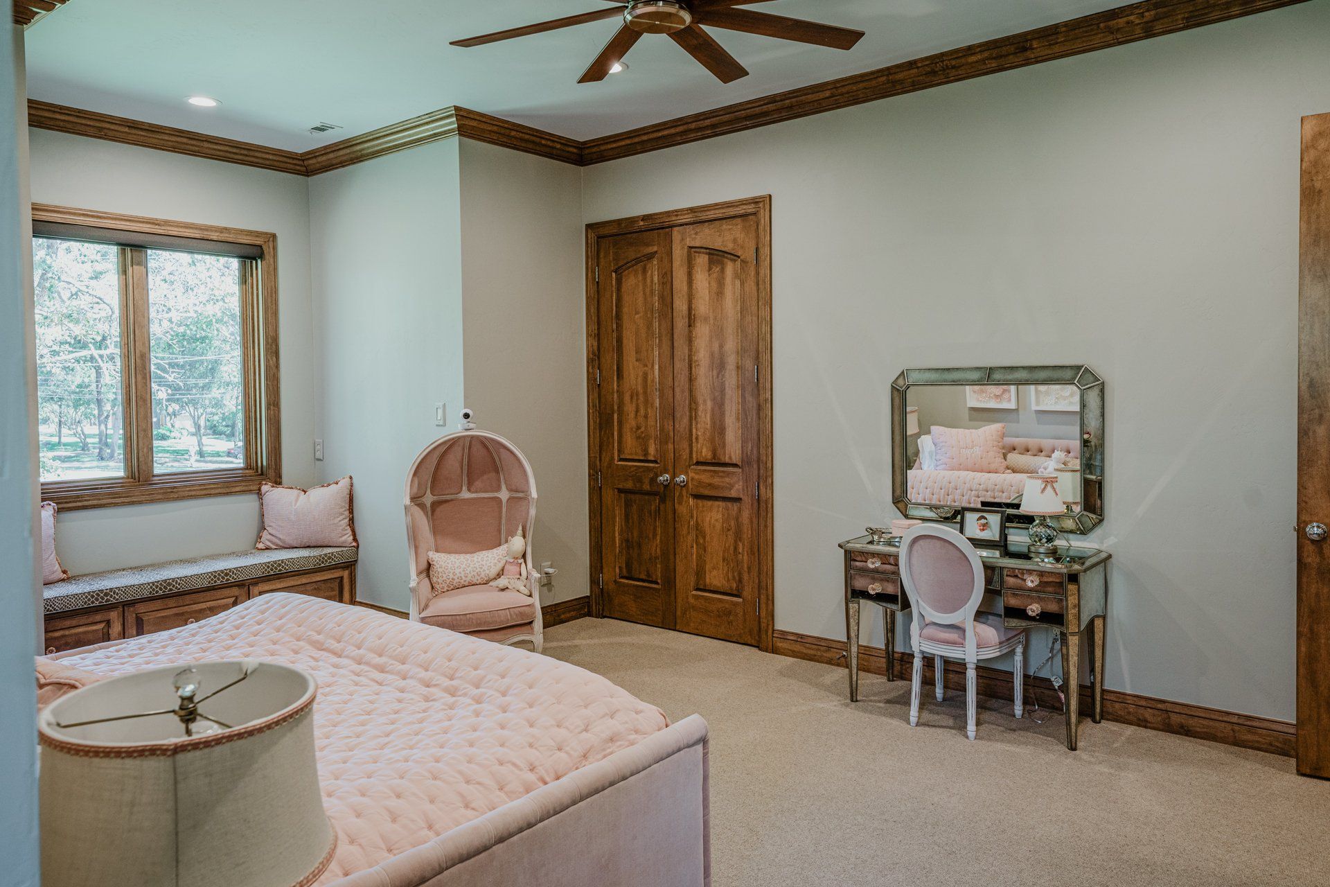 A bedroom with a bed , chair , desk and mirror.