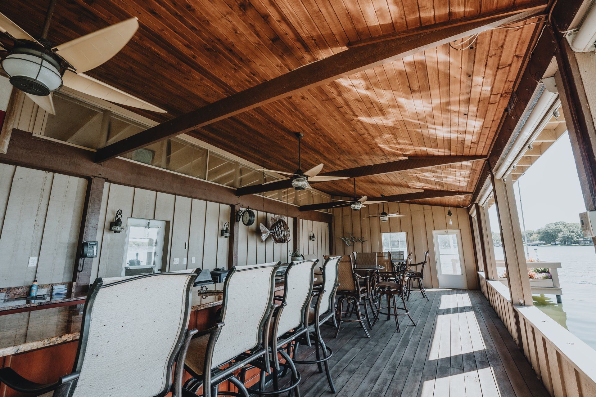 A large room with a wooden ceiling and tables and chairs